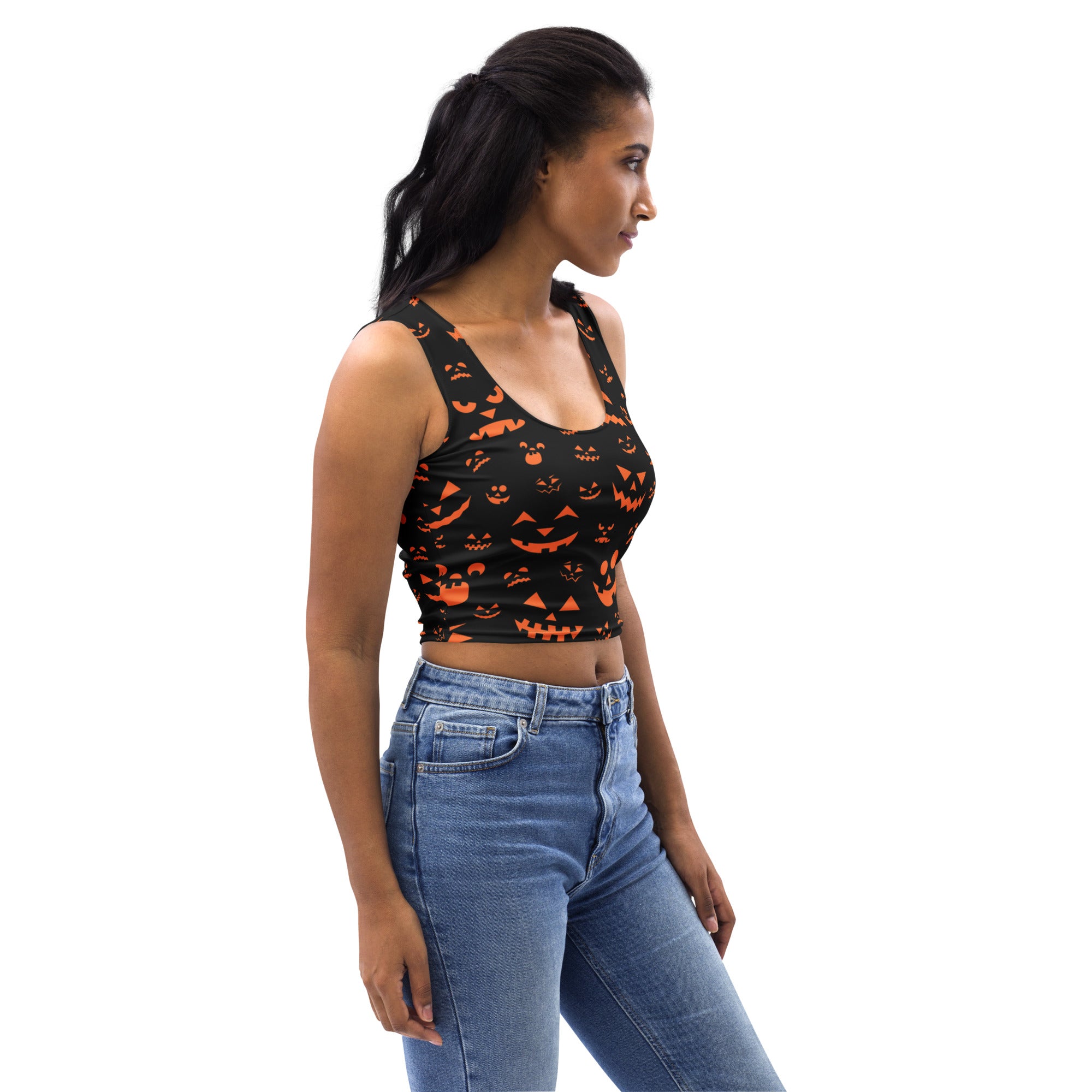 Women’s black buttery soft crop top with orange jack-o-lantern faces printed for halloween wear