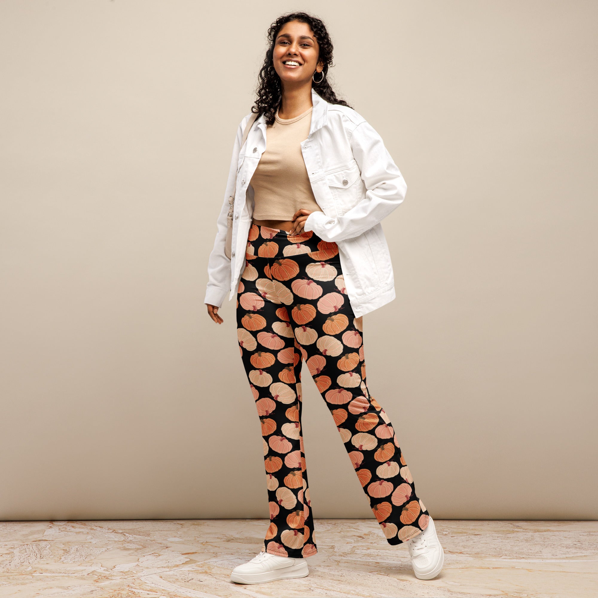 Women’s black high waist flare legging pants with a playful orange and pink pumpkin pattern