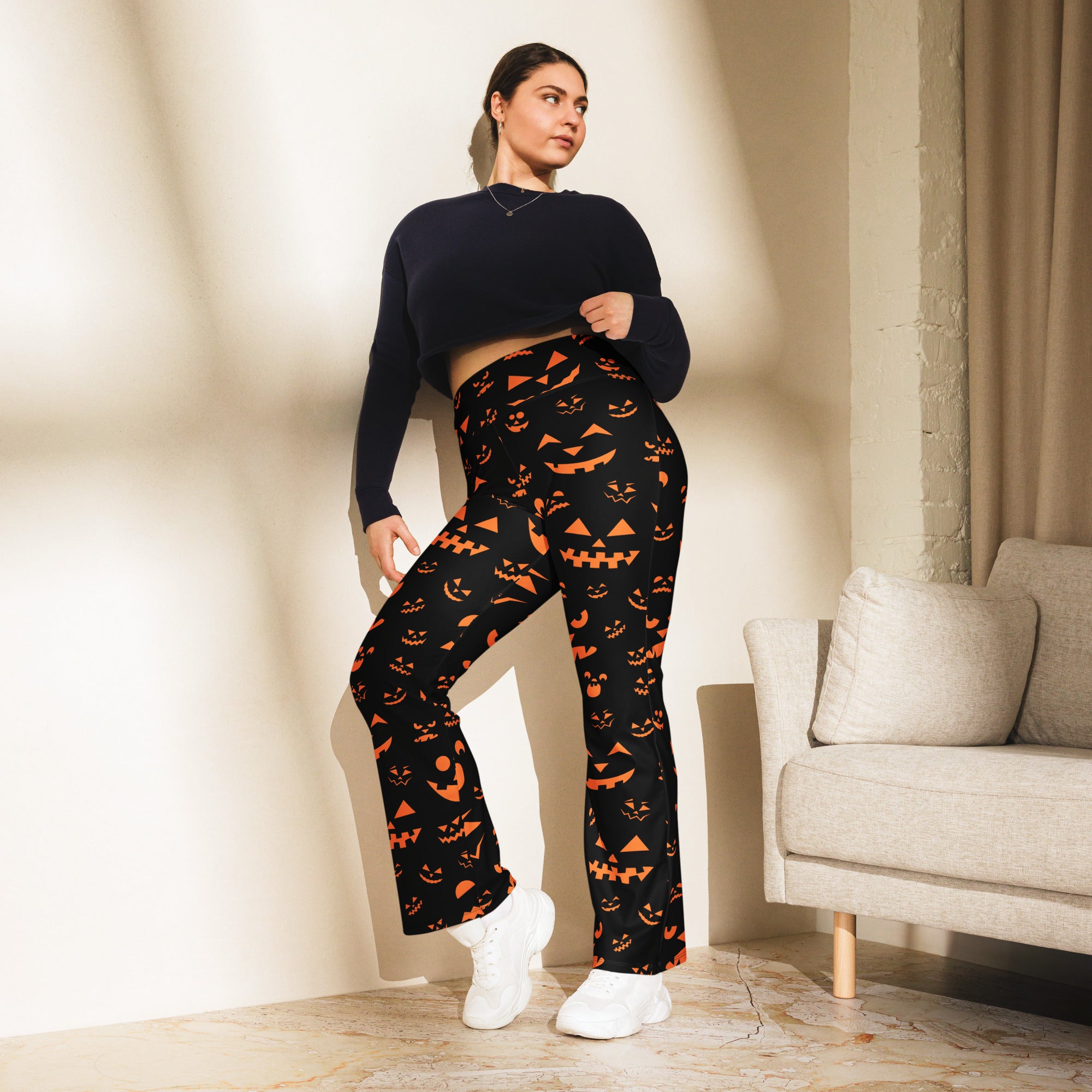 Women’s black halloween-themed high waist flare leggings with orange jack-o-lantern faces and triangular patterns