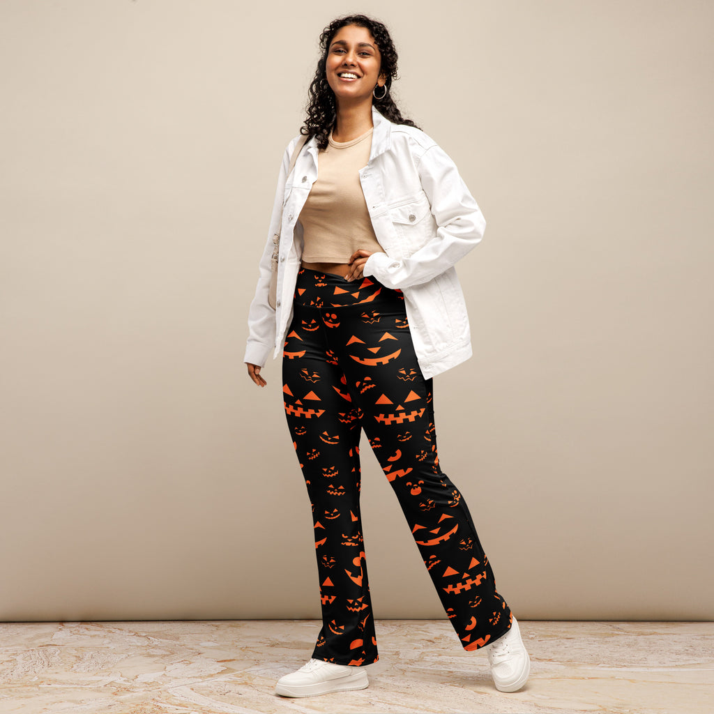 Women’s black high waist flare legging pants with orange jack o lantern faces printed for halloween wear
