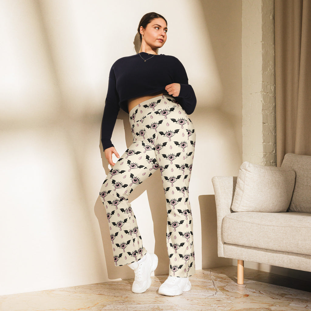 Cream-colored plus-size high waist flare legging pants with black bat eye motif and teardrop accents for women