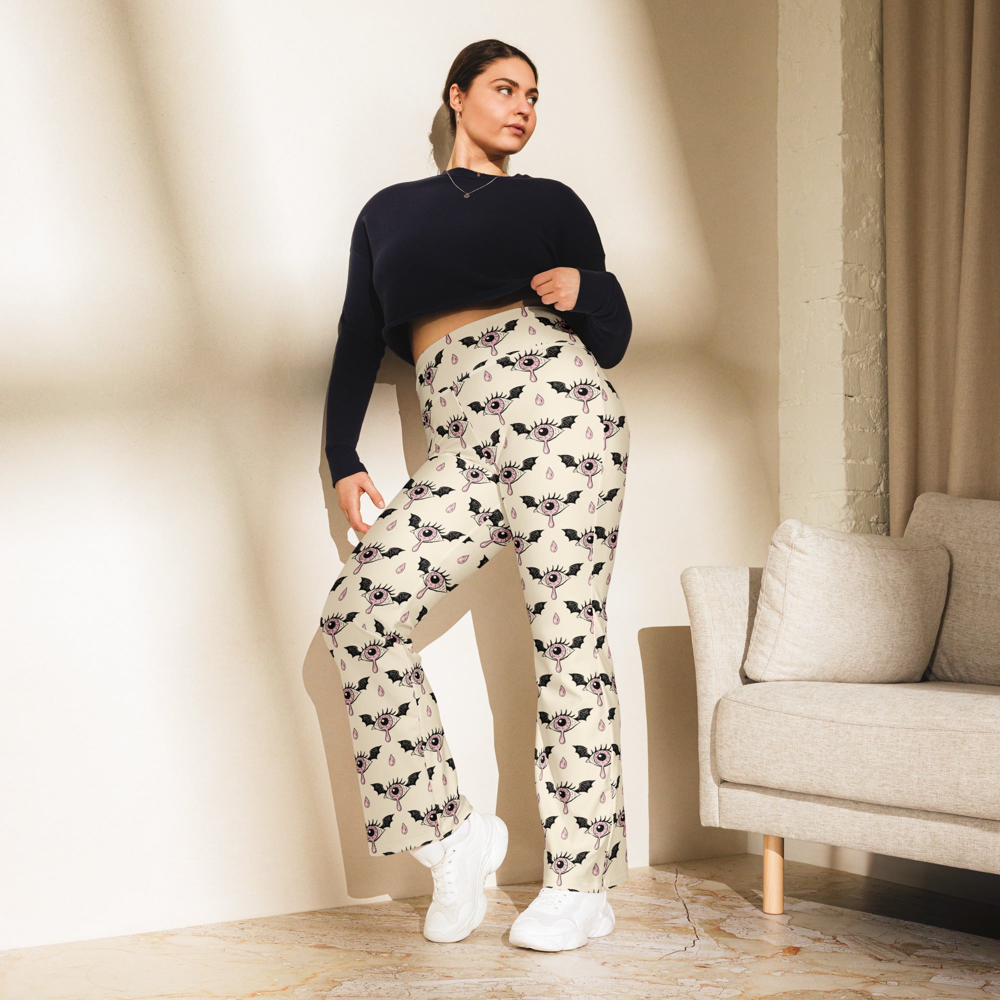Cream-colored plus-size high waist flare legging pants with black bat eye motif and teardrop accents for women