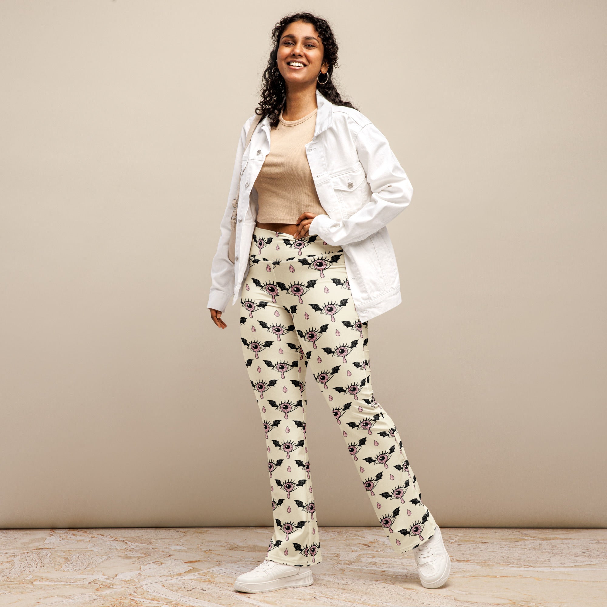 Cream-colored women’s gothic high waist flare legging pants with black bats and eyeball teardrop pattern