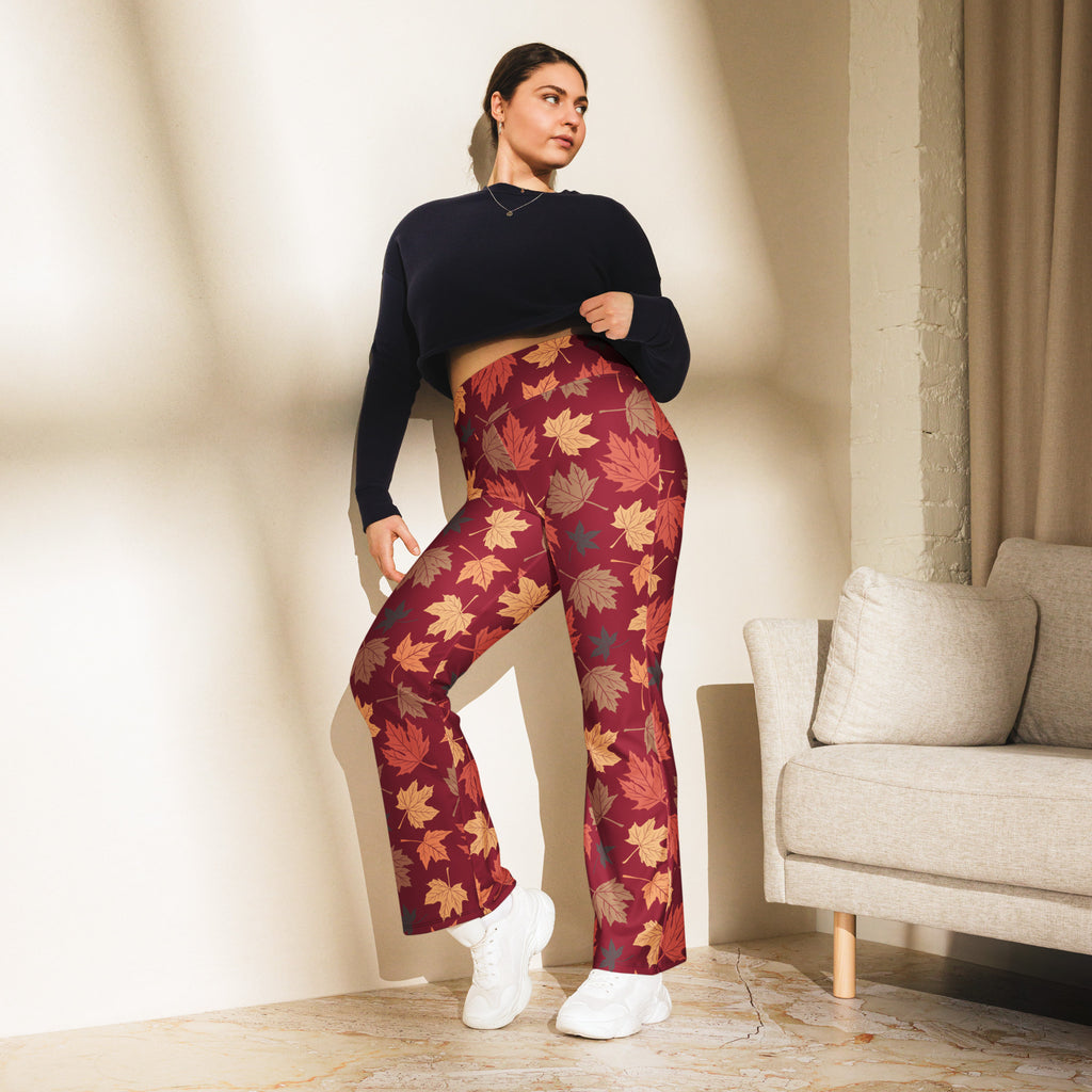 Plus-size woman wearing maroon high waist flare leggings with vibrant orange yellow and brown autumn leaf pattern