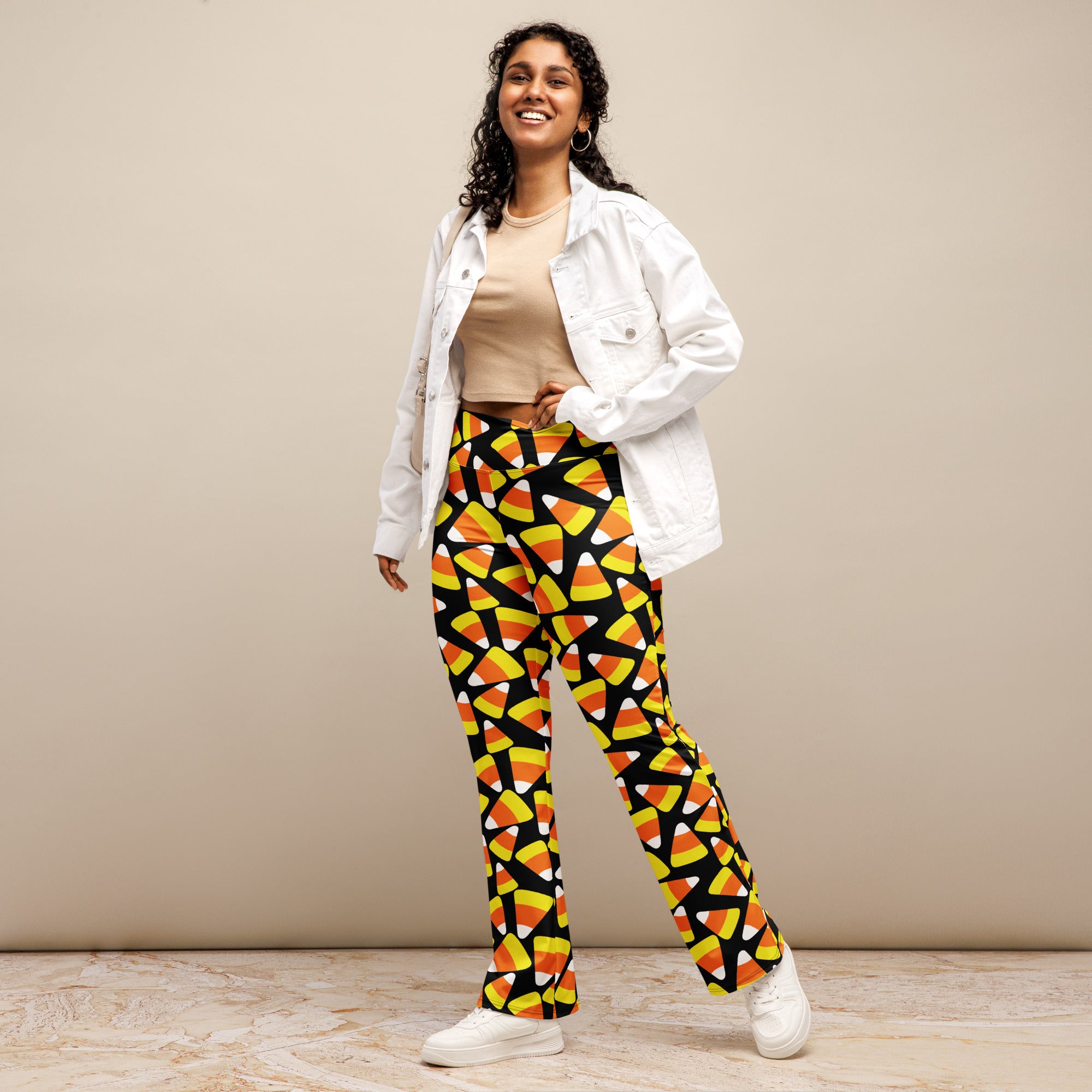 Women’s candy corn high waist flare legging pants in vibrant orange yellow white pattern on black fabric
