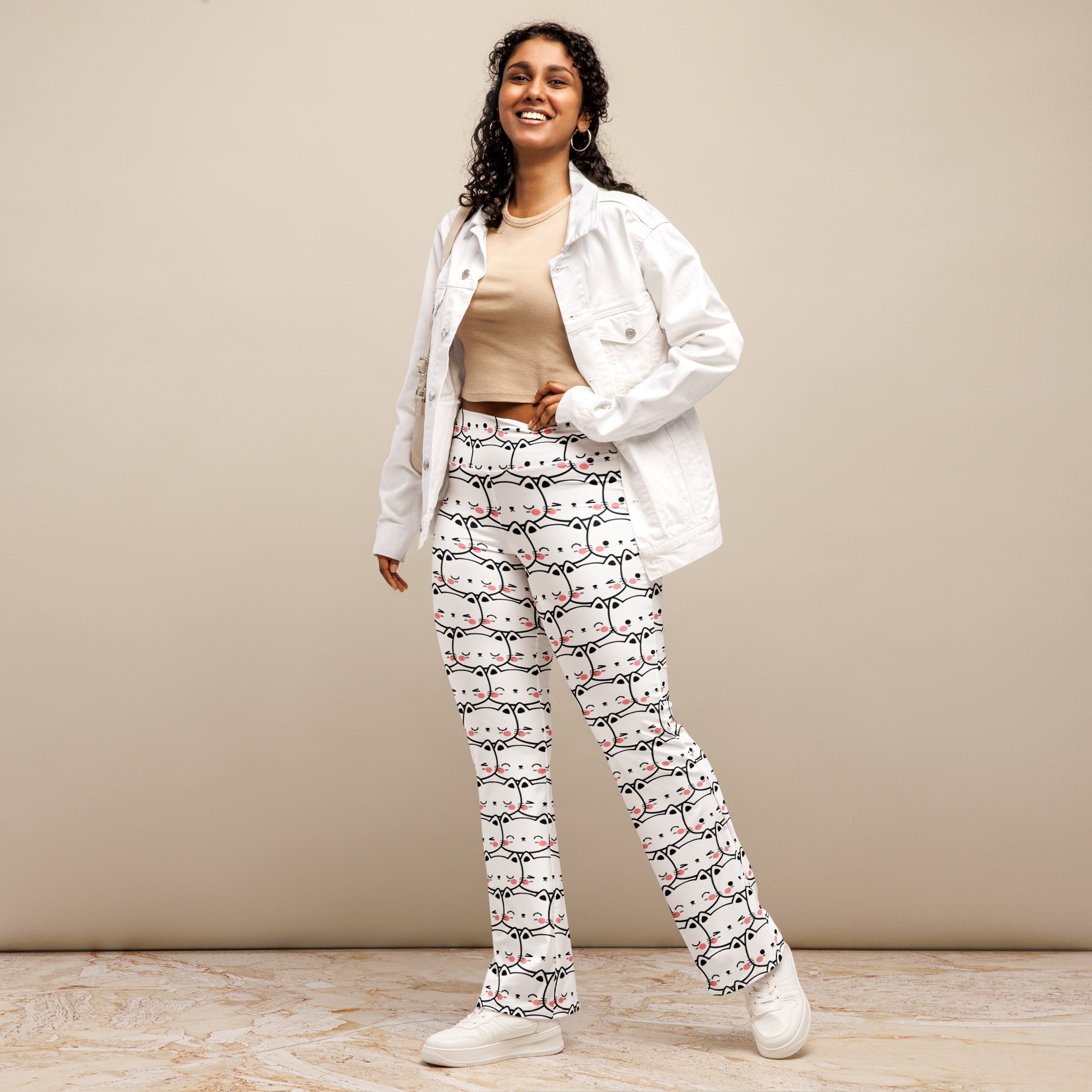 Women’s white high waist flare leggings with playful black and pink cartoon cat face print pattern