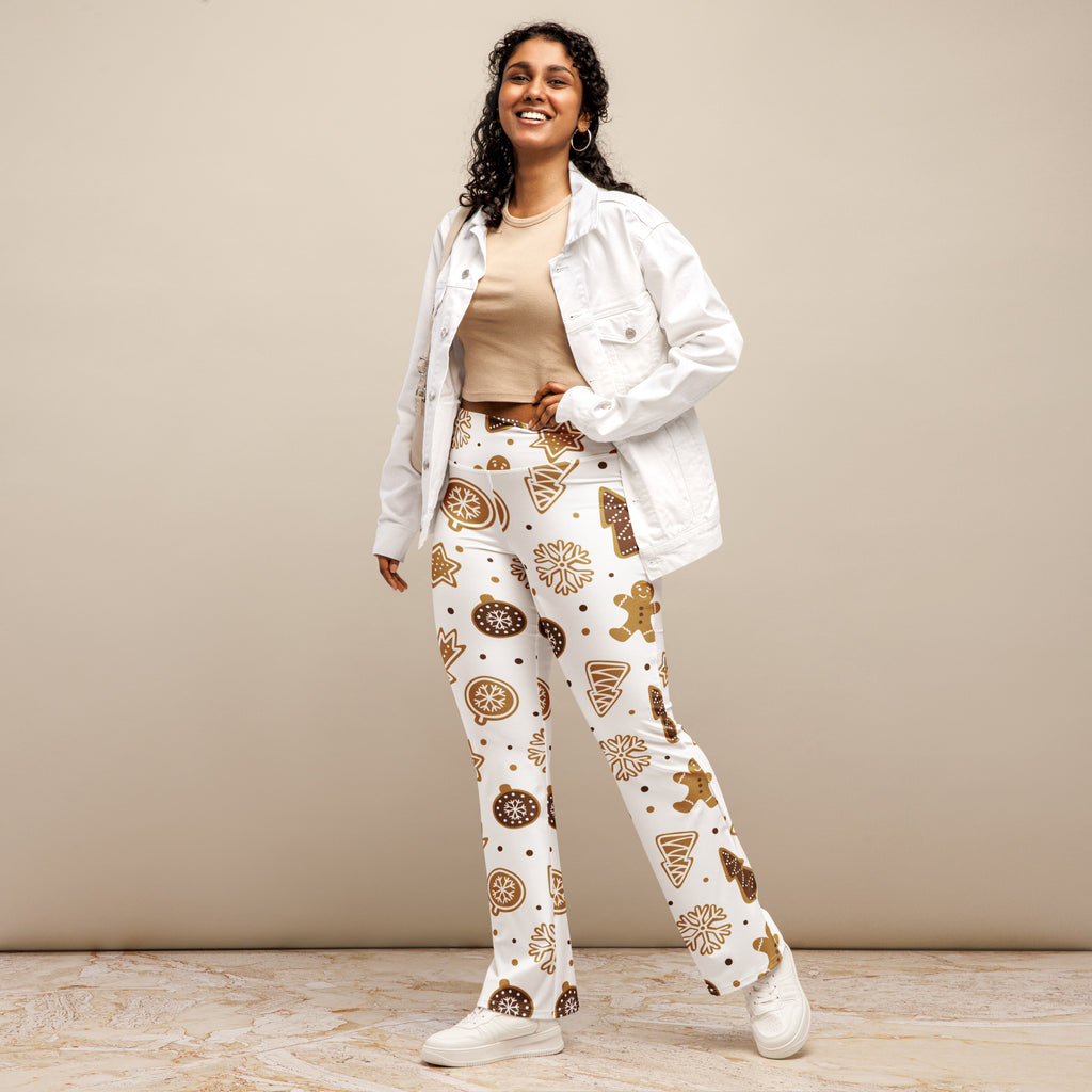 White women’s high waist flare legging pants with festive gingerbread cookie print and snowflake ornaments