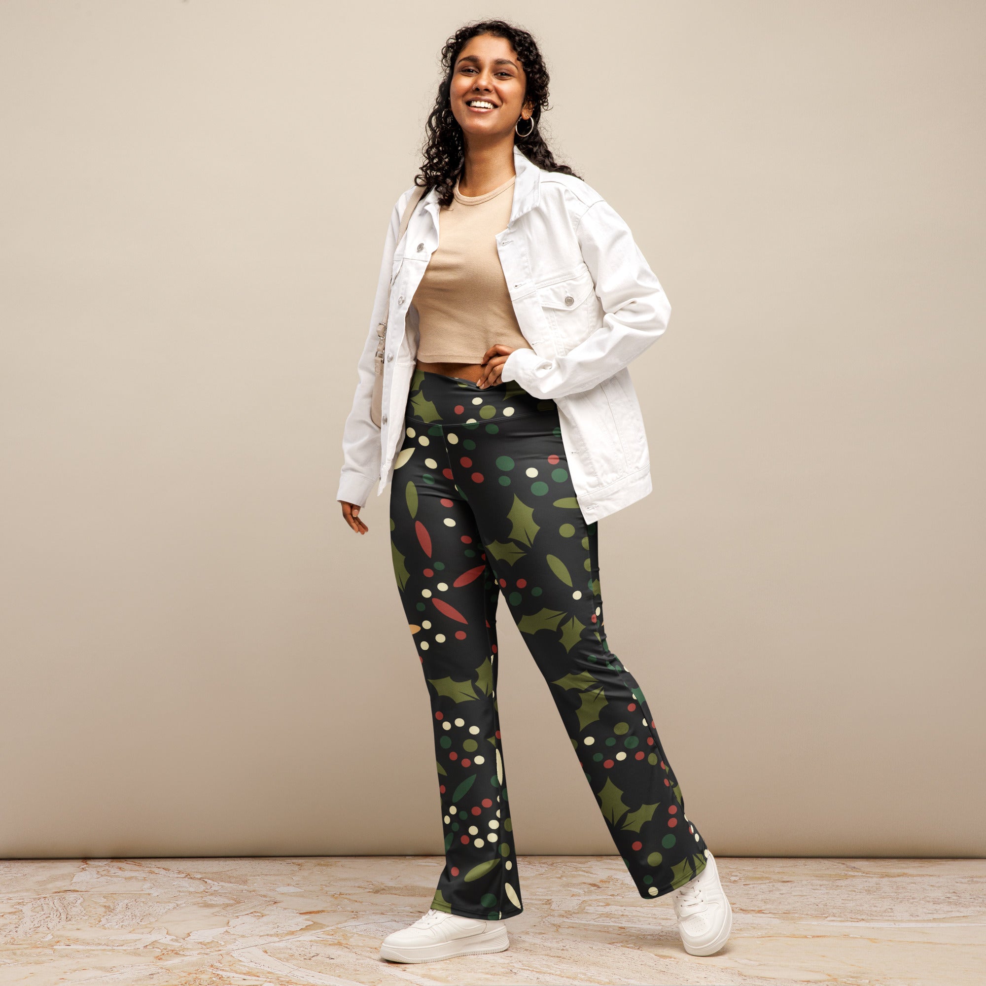 Women’s black high waist flare leggings with festive green holly leaves red berries and white dot pattern