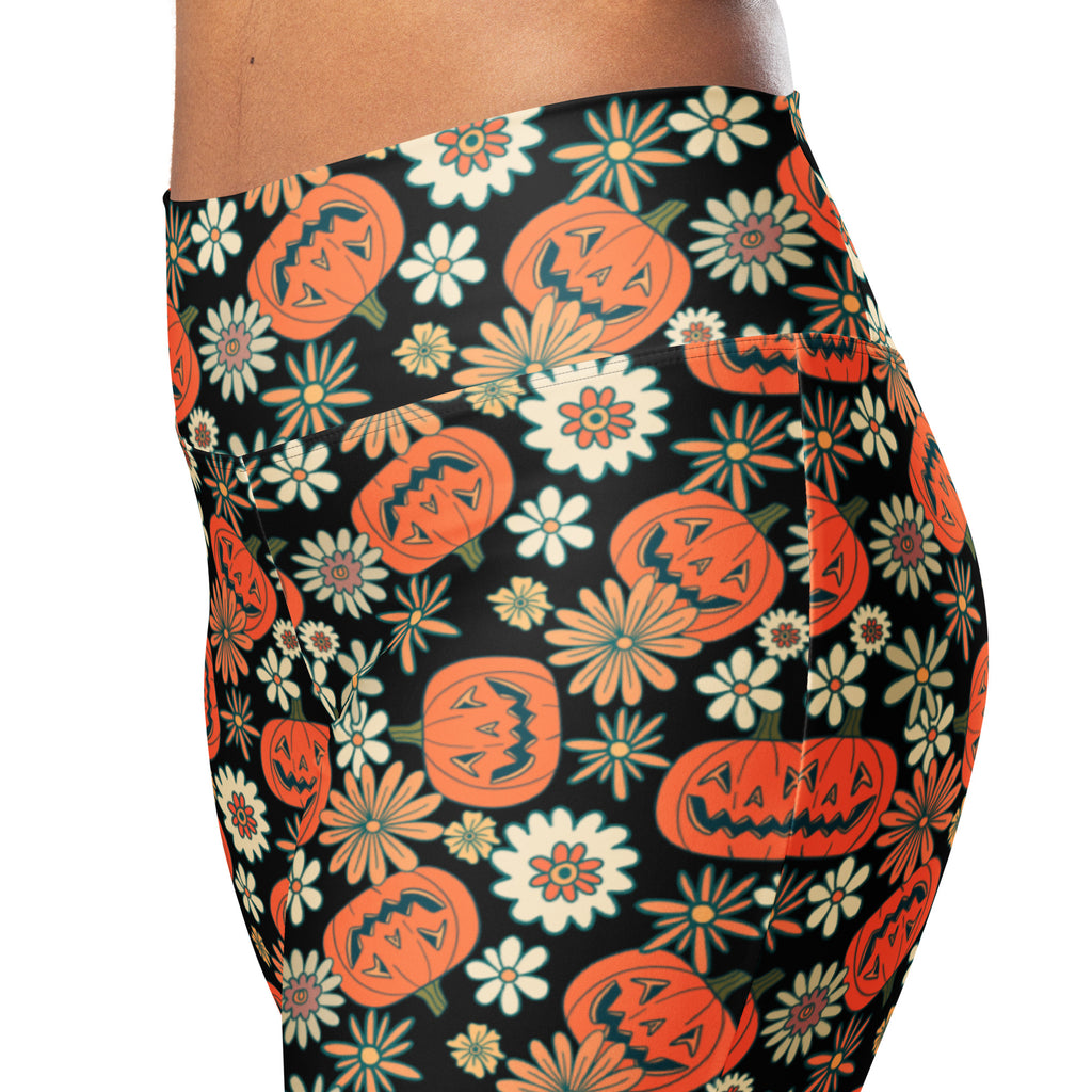 Black high waist flare leggings with vibrant orange jack o lantern and multicolored floral pattern for women