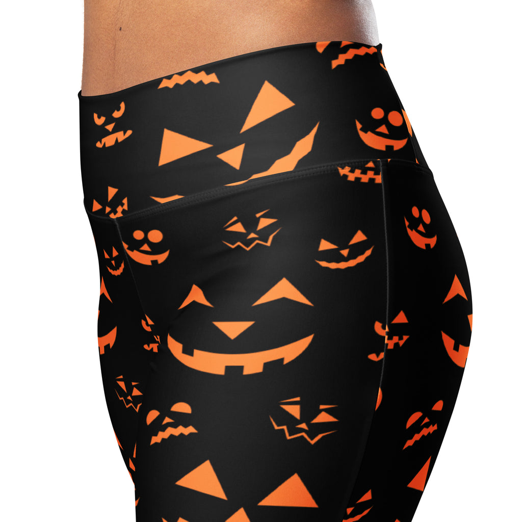 Women’s black high waist flare leggings with vibrant orange jack-o-lantern face pattern for Halloween wear
