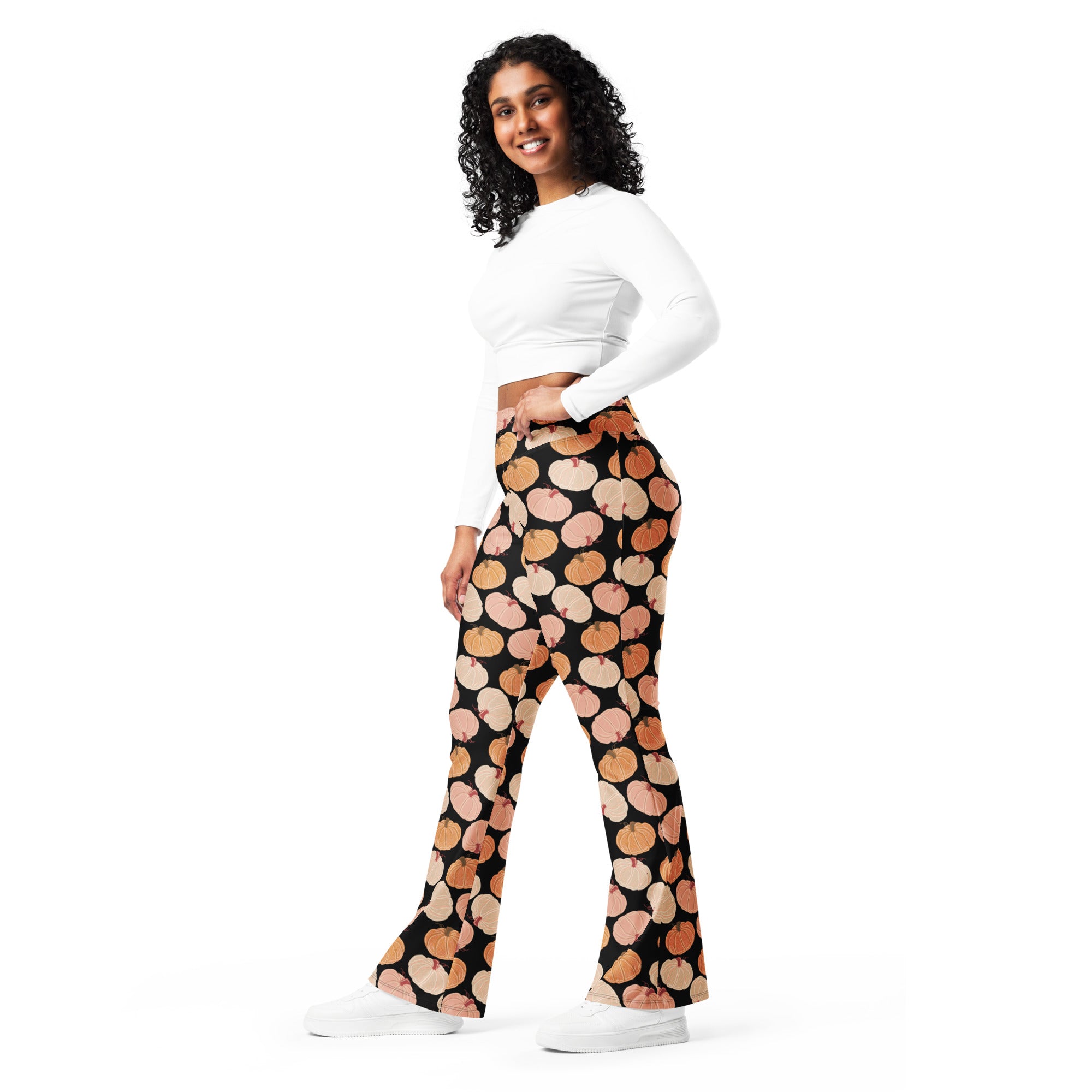 Women’s black high waist flare legging pants with a playful peach and orange pumpkin pattern for fall wear