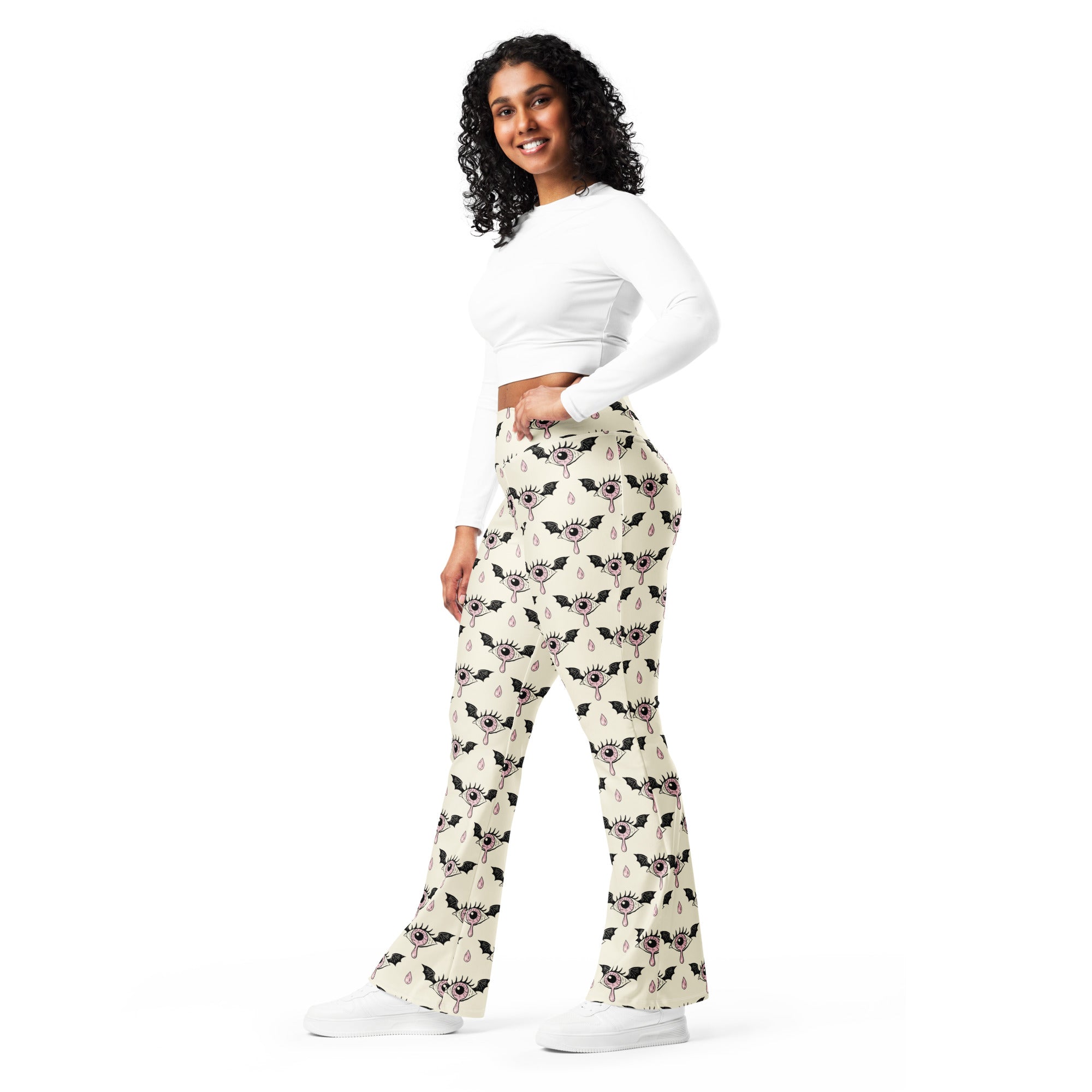 Women’s cream-colored high waist flare legging pants with black bat eyeball pattern and teardrop accents