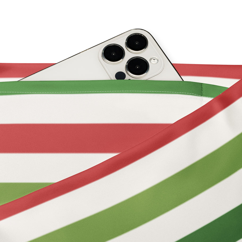 White iphone with triple camera peeking from red white and green strap next to women’s yellow high waist flare leggings