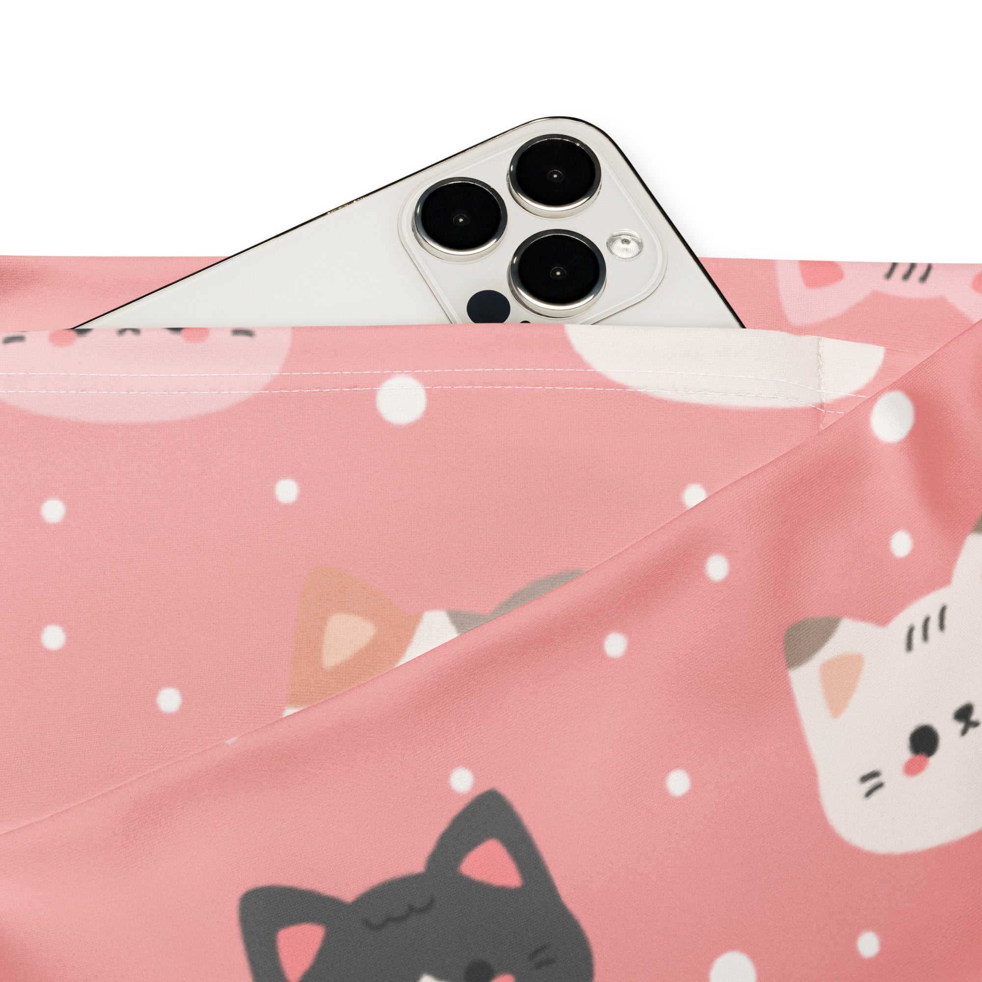 Pink fabric pouch with cute cartoon cat faces and white polka dots holding a silver smartphone in front of pink leggings