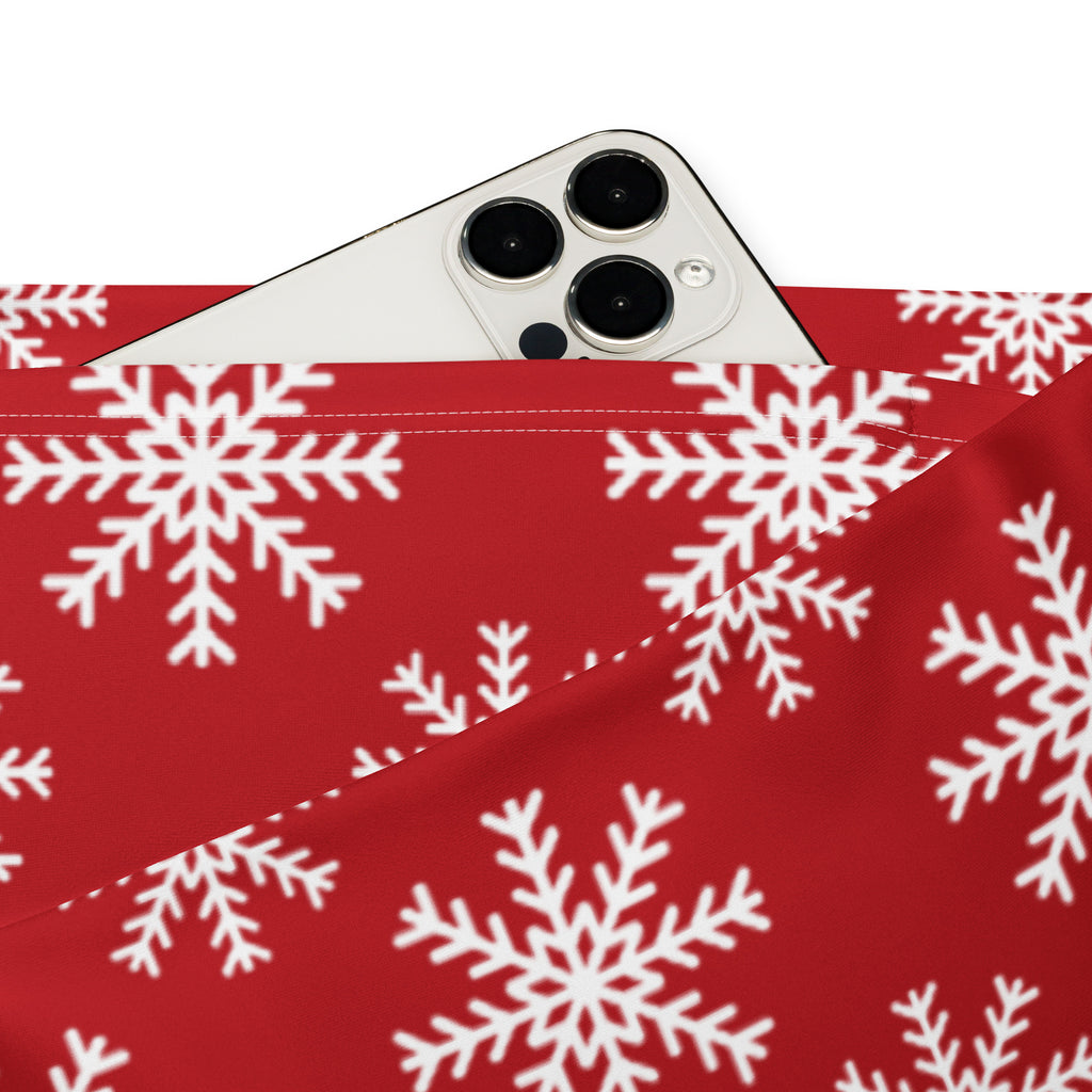 Red fabric pouch with white snowflake pattern holding a silver iphone paired with women’s red snowflake high waist flare leggings