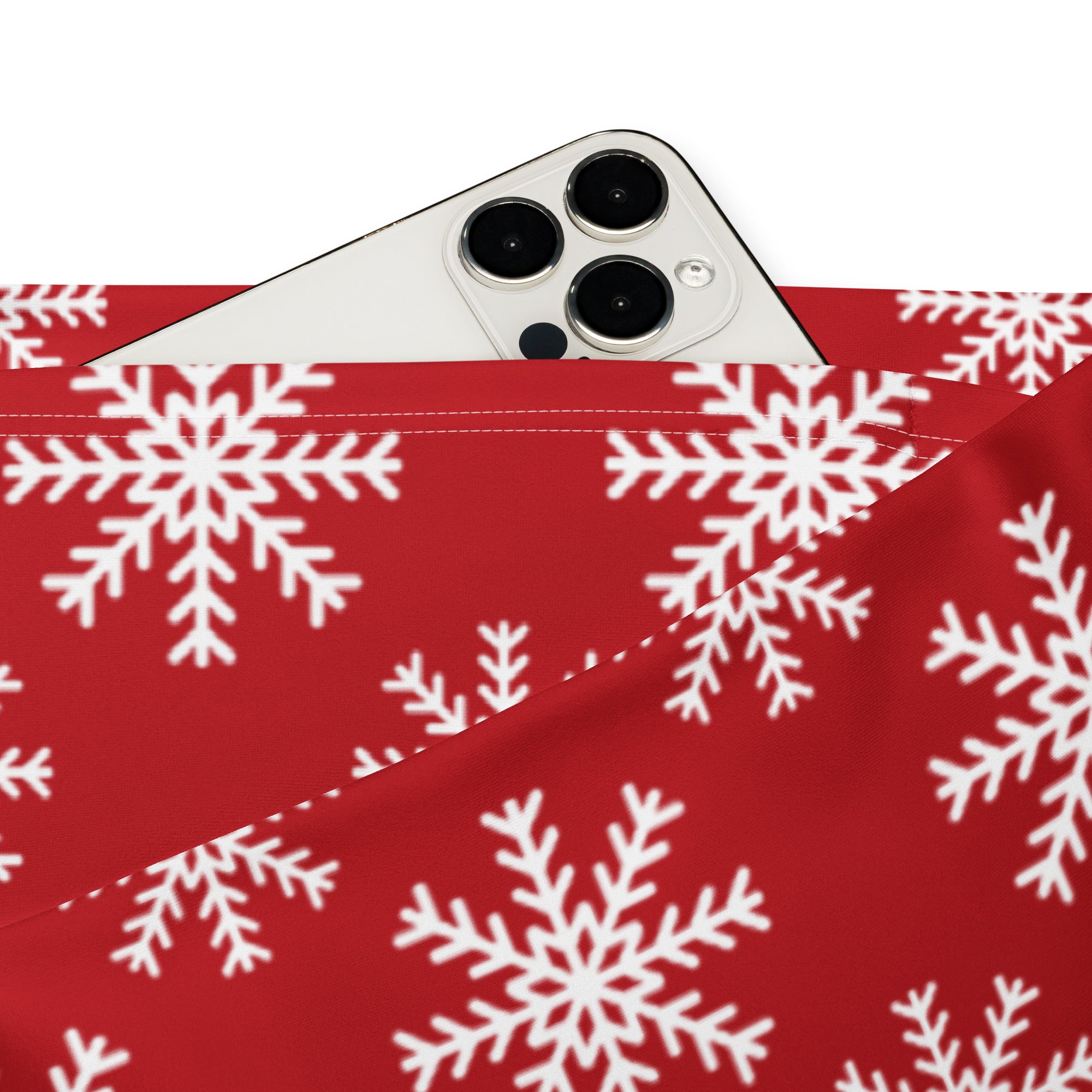 Red fabric pouch with white snowflake pattern holding a silver iphone paired with women’s red snowflake high waist flare leggings