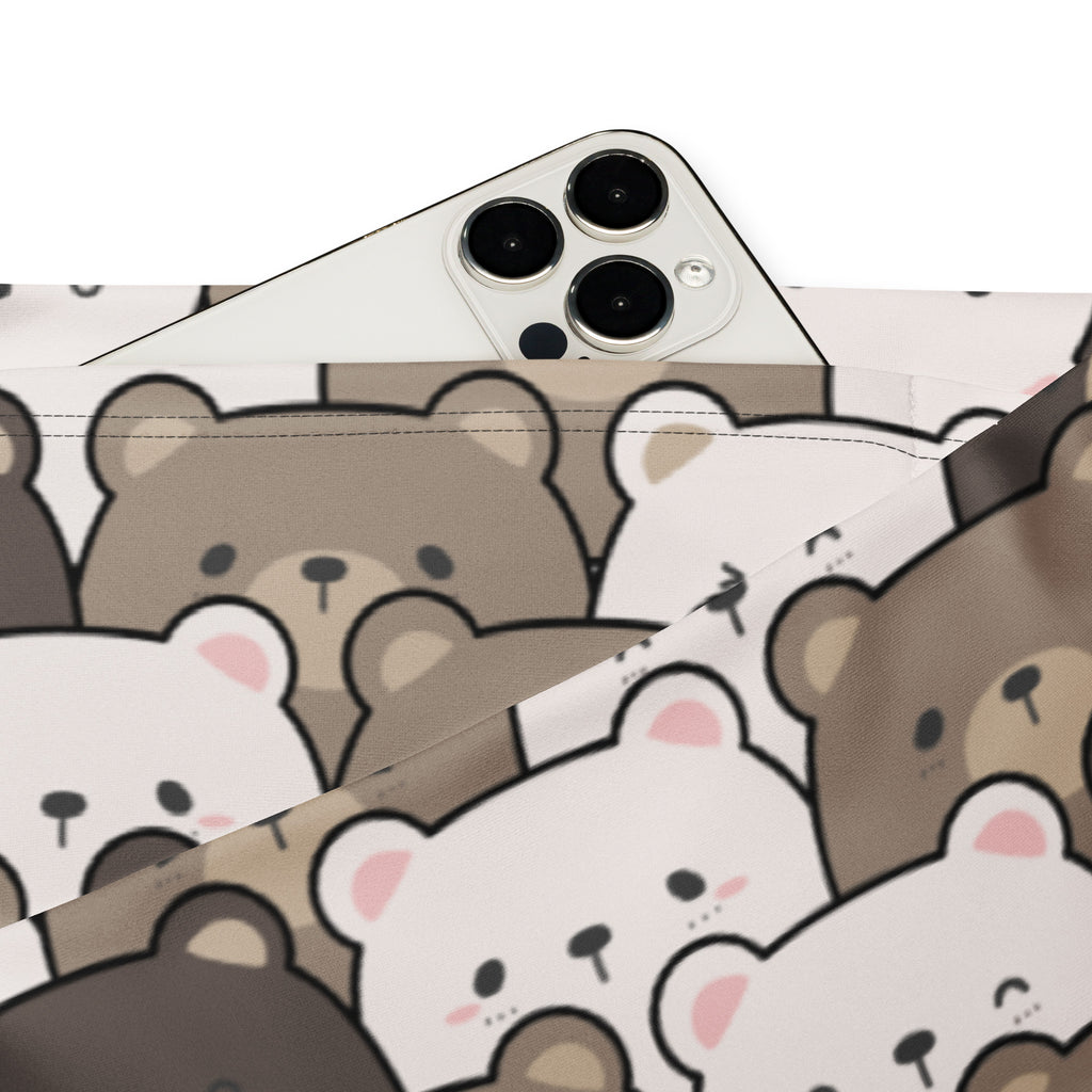 A white smartphone on fabric patterned with cute brown and white cartoon bears under women’s cute bear print high waist flare legging pants