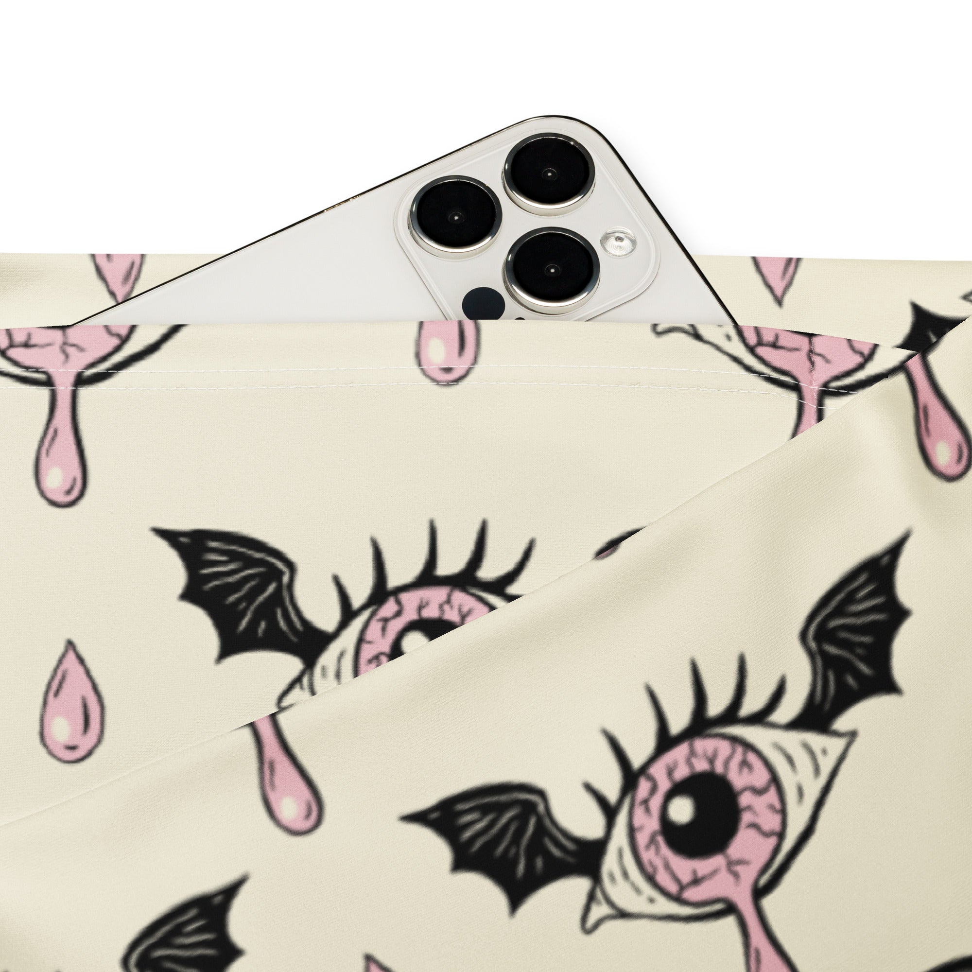 A cream fabric pouch with a gothic eyeball bat pattern featuring black wings and pink droplets