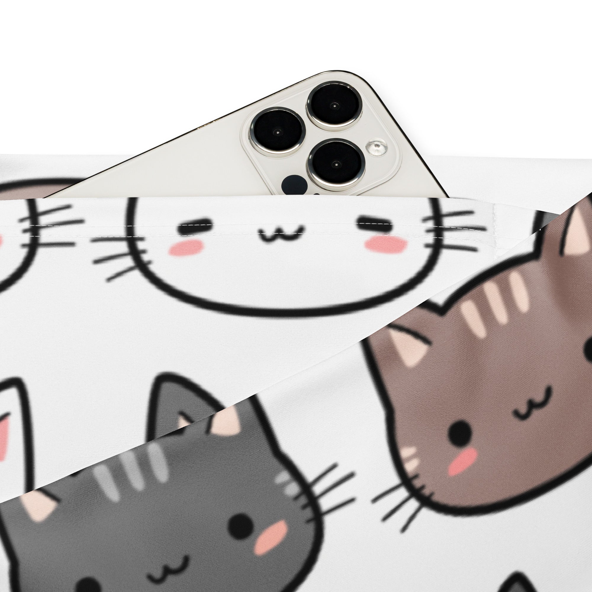 White smartphone with silver triple lens camera module shown next to women’s cute cat print high waist flare leggings