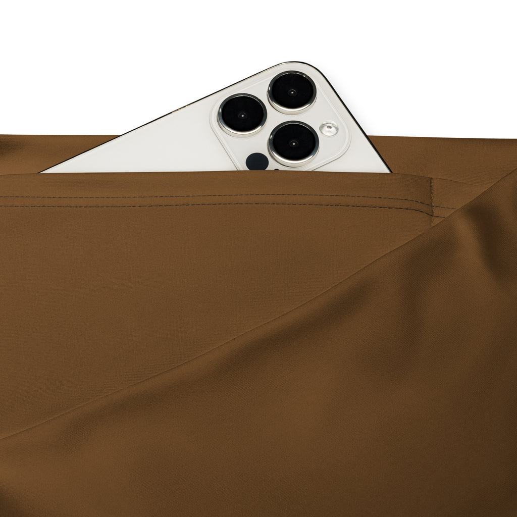 A white iphone with triple lens camera peeking from the back pocket of women brown high waist flare legging pants