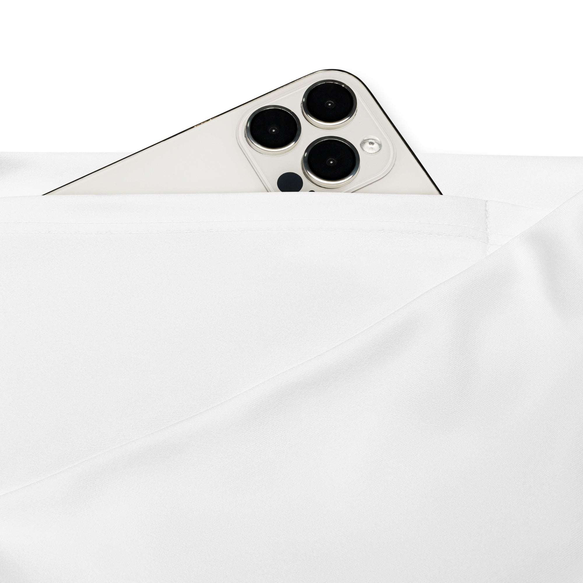A sleek white iphone 13 pro with triple lens camera peeking from soft fabric alongside women’s white high waist flare leggings