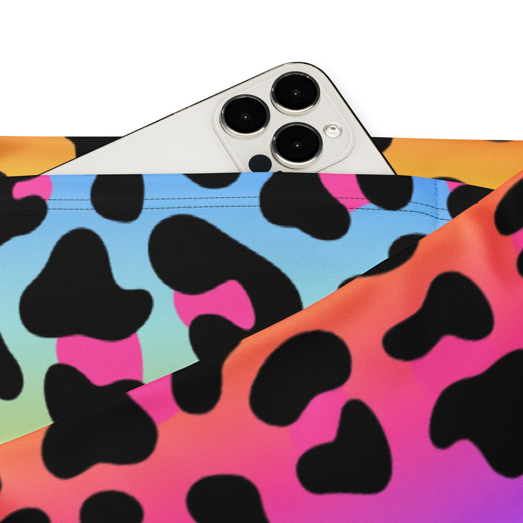 A white iphone with triple camera on vibrant rainbow leopard high waist flare legging pants fabric