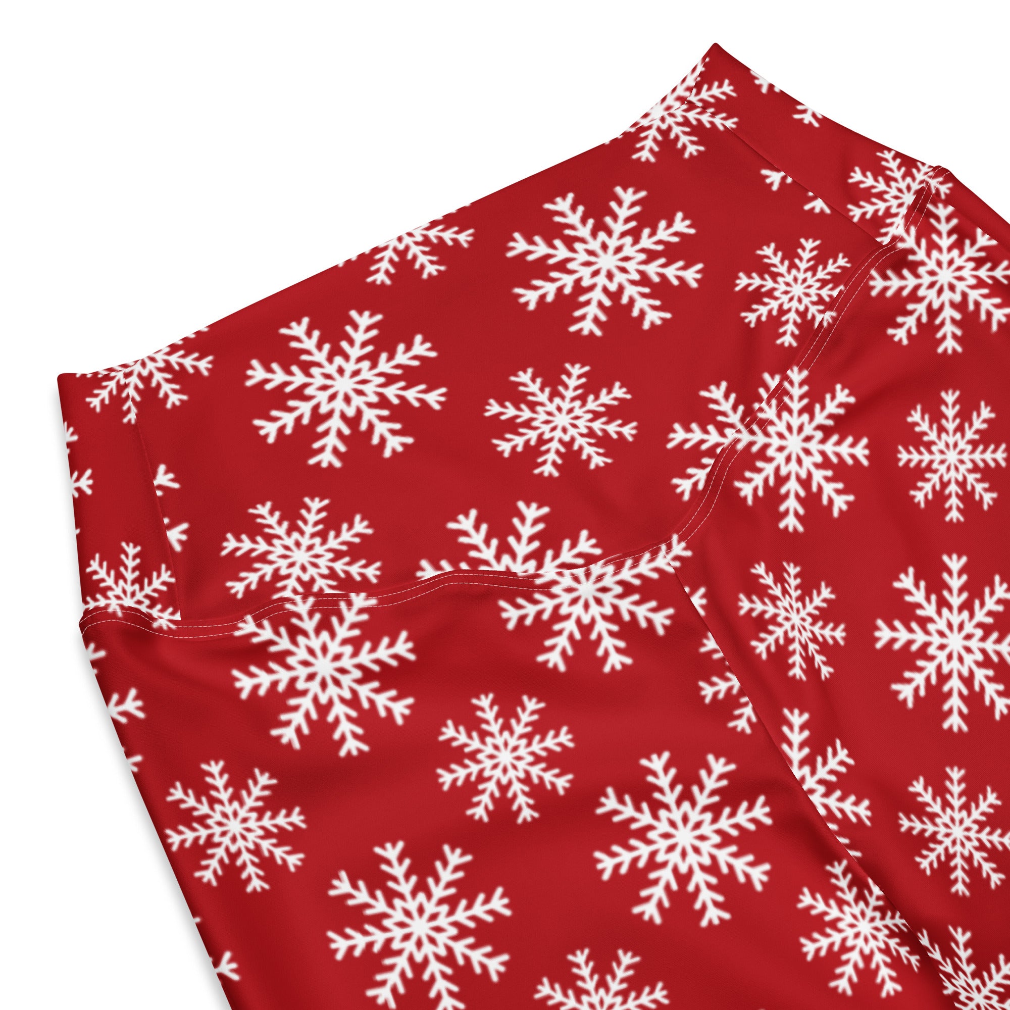 Red leggings featuring a repeating pattern of white snowflakes.