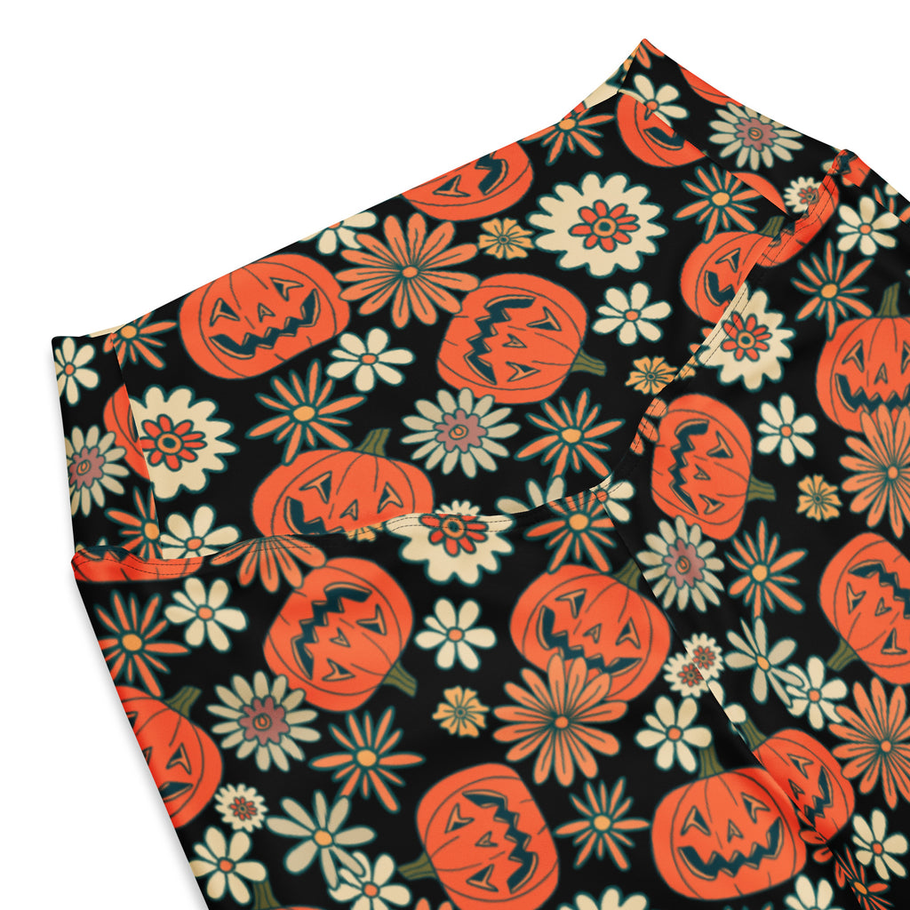 Women’s retro halloween high waist flare legging pants with black fabric featuring orange jack-o-lanterns and flowers
