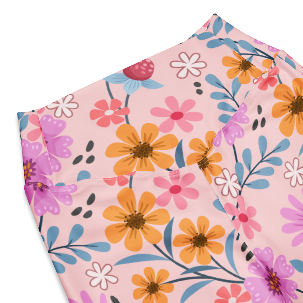 Women’s pink floral high waist flare legging pants with vibrant orange pink purple flowers and blue stems on pastel background