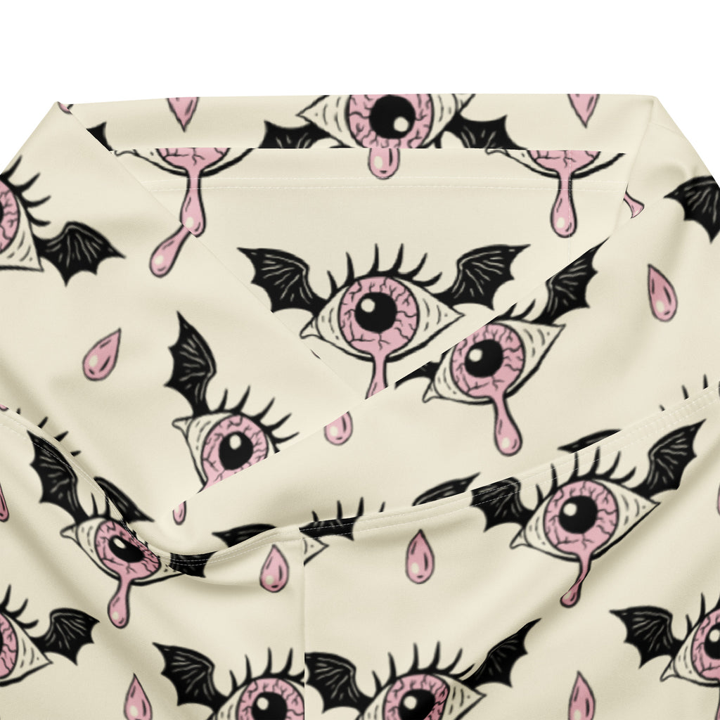 Cream-colored women’s gothic eyeball bat high waist flare leggings with pink eyeball wing pattern and black droplets