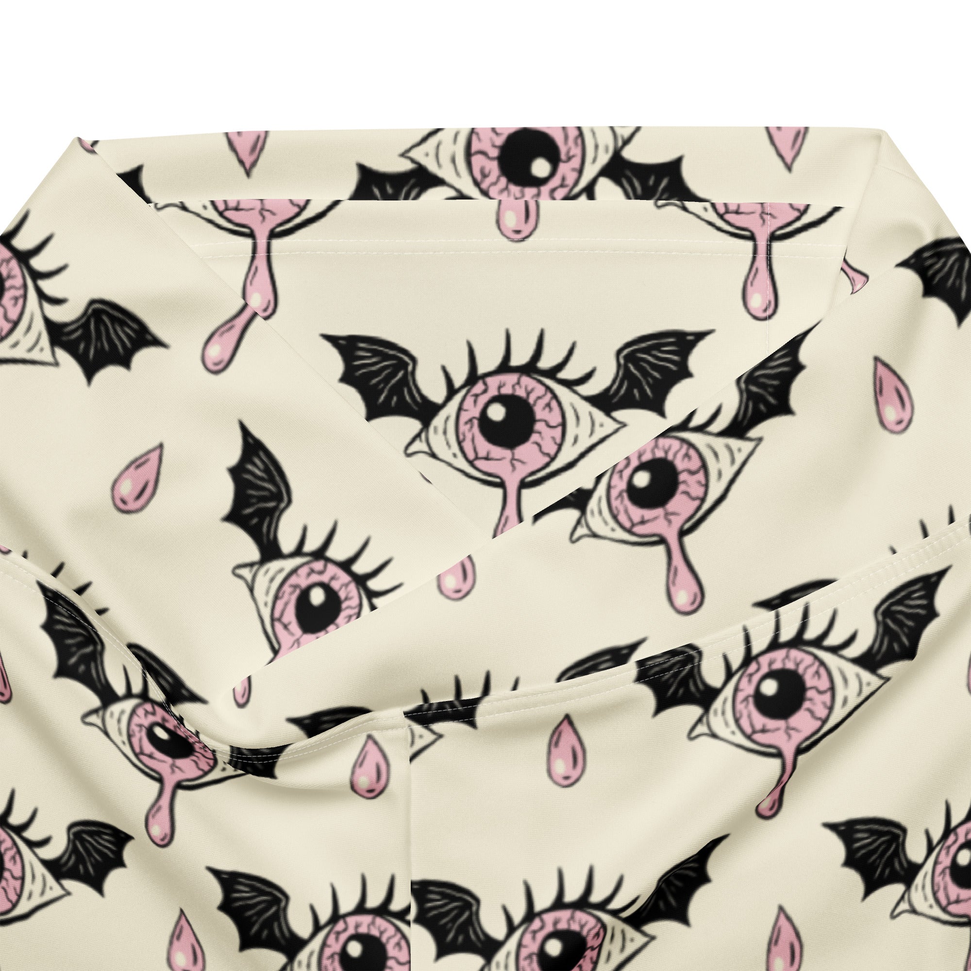 Cream-colored women’s gothic eyeball bat high waist flare leggings with pink eyeball wing pattern and black droplets