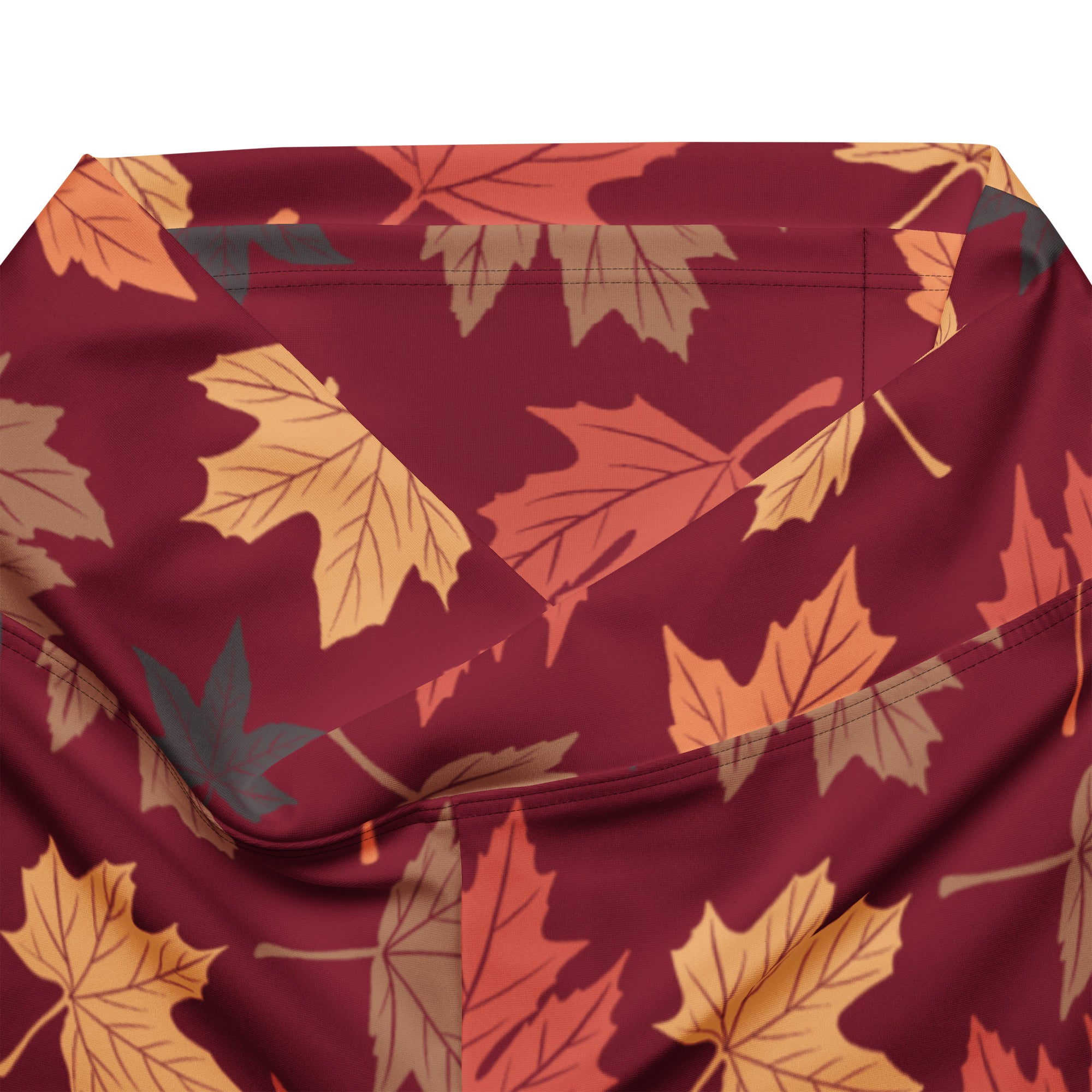 Women’s maroon high waist flare legging pants with autumn leaves pattern in orange yellow and brown on fabric