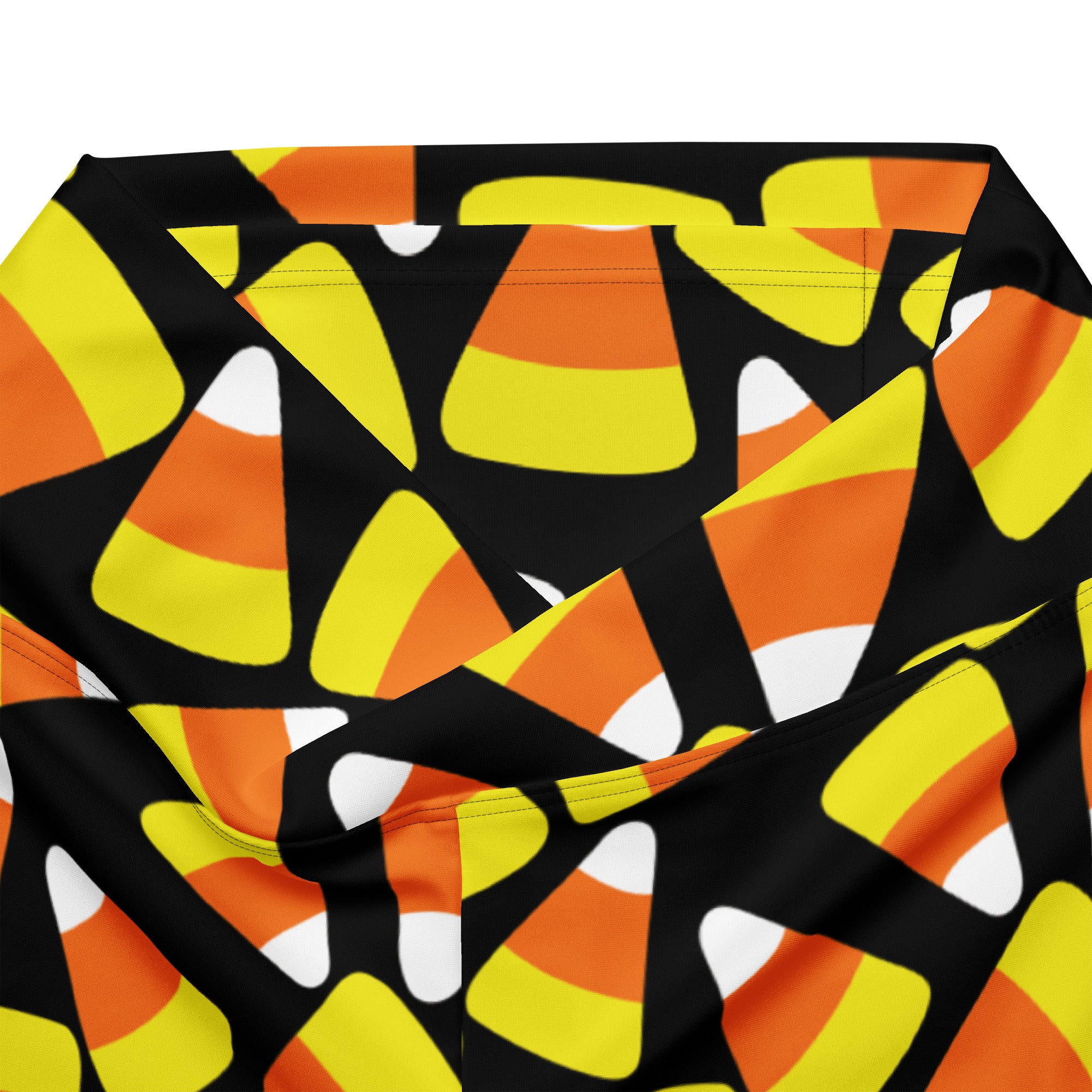 Women’s candy corn high waist flare legging pants in black fabric with vibrant orange yellow and white candy corn pattern