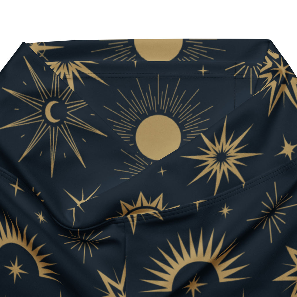 A navy blue fabric pouch with a gold celestial pattern of suns, moons, and stars for women’s flare leggings