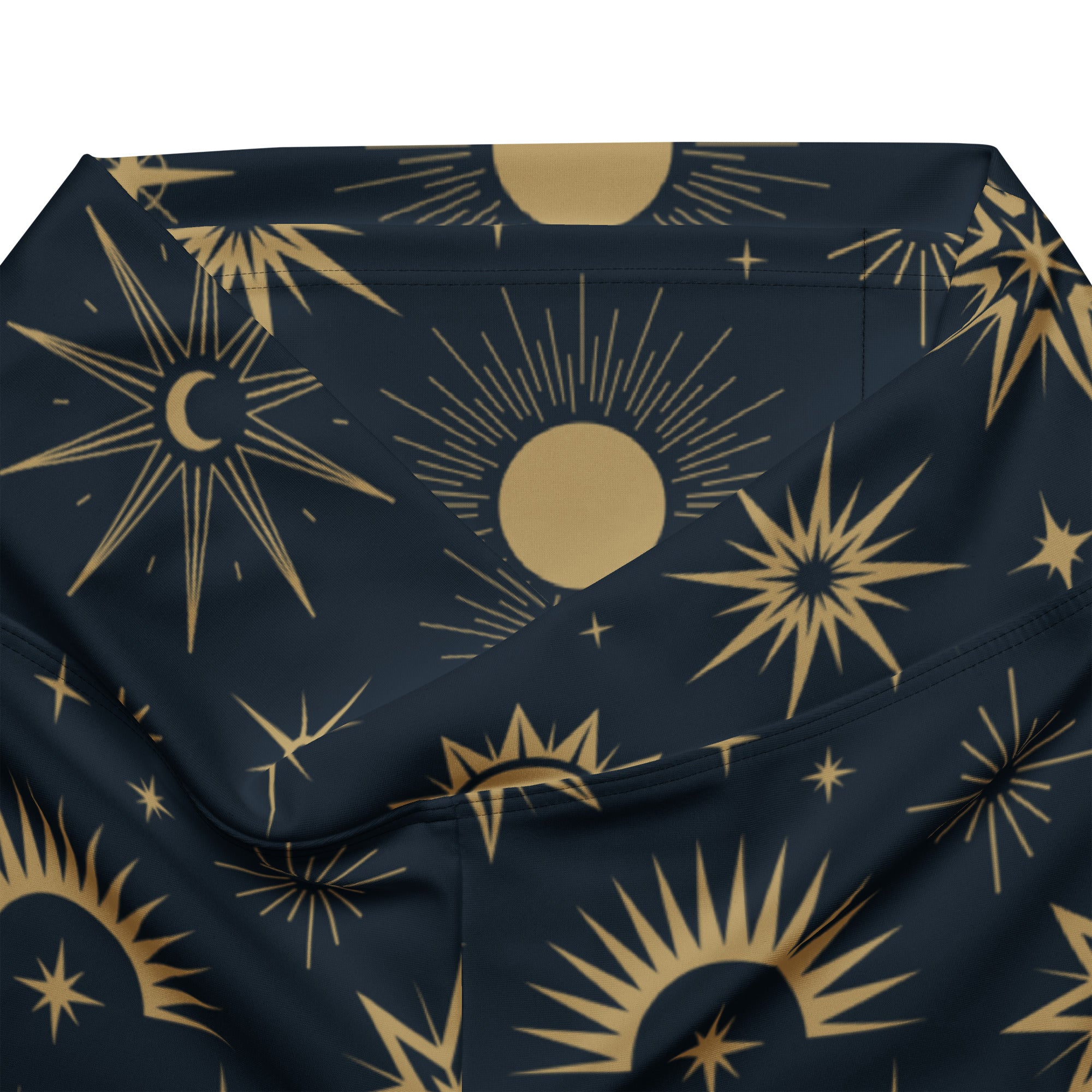 A navy blue fabric pouch with a gold celestial pattern of suns, moons, and stars for women’s flare leggings