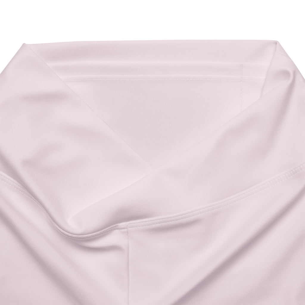 A soft pale pink satin pillowcase with smooth folds and subtle sheen paired with women’s light pink high waist flare legging pants