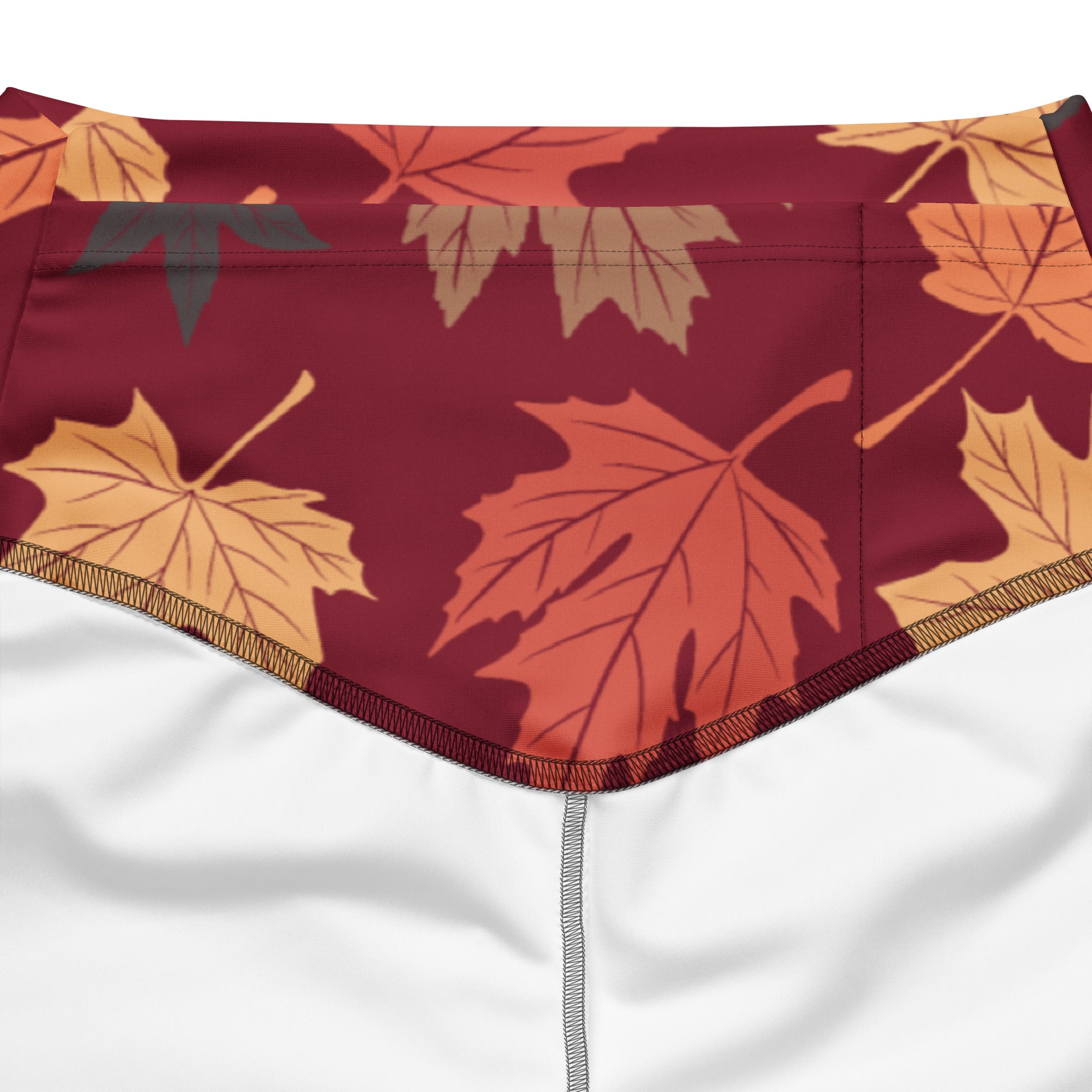 Women’s autumn leaves high waist flare legging pants in maroon fabric with orange and yellow maple leaf pattern and stitched edges