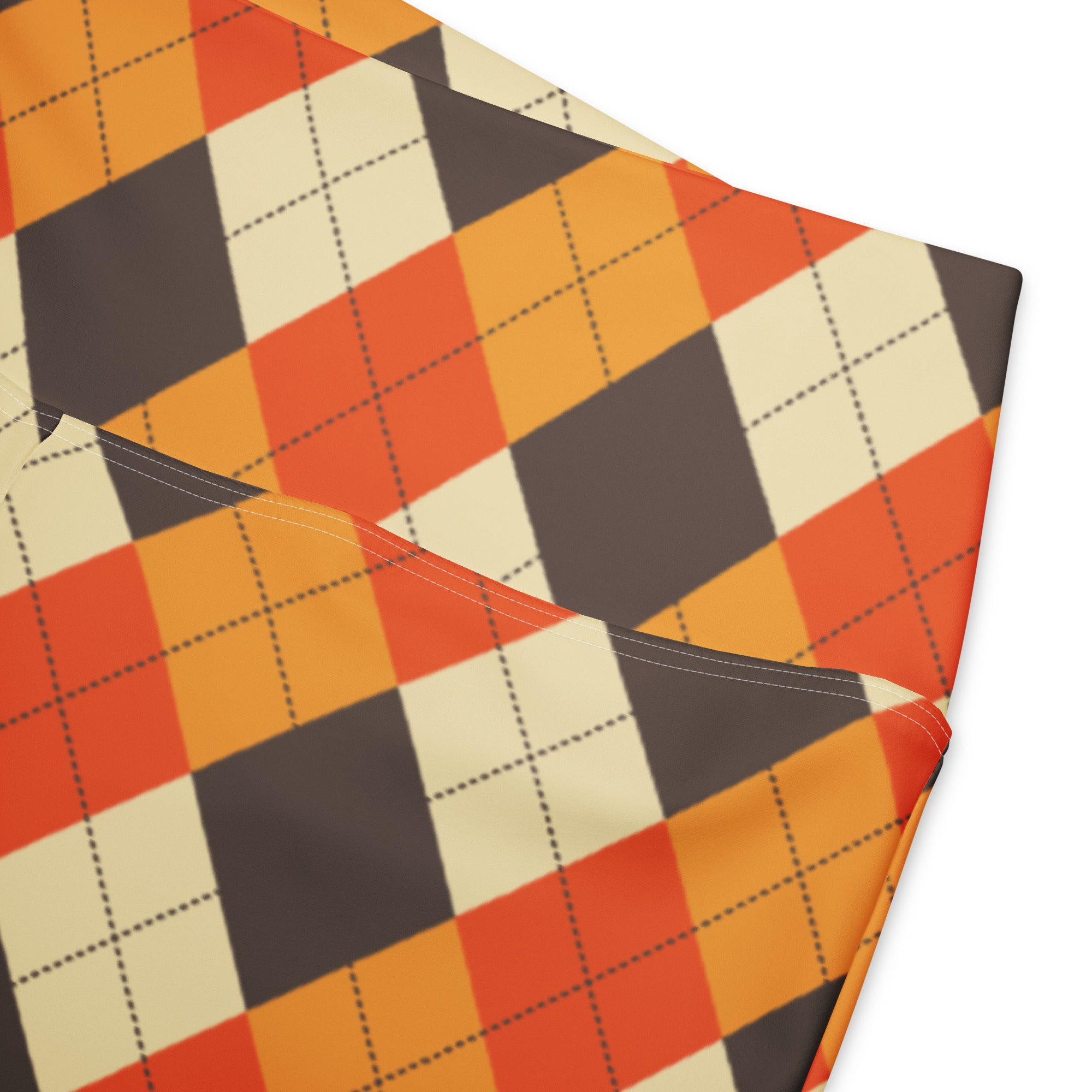 A folded pair of women’s fall argyle high waist flare leggings with bold orange cream and dark gray pattern