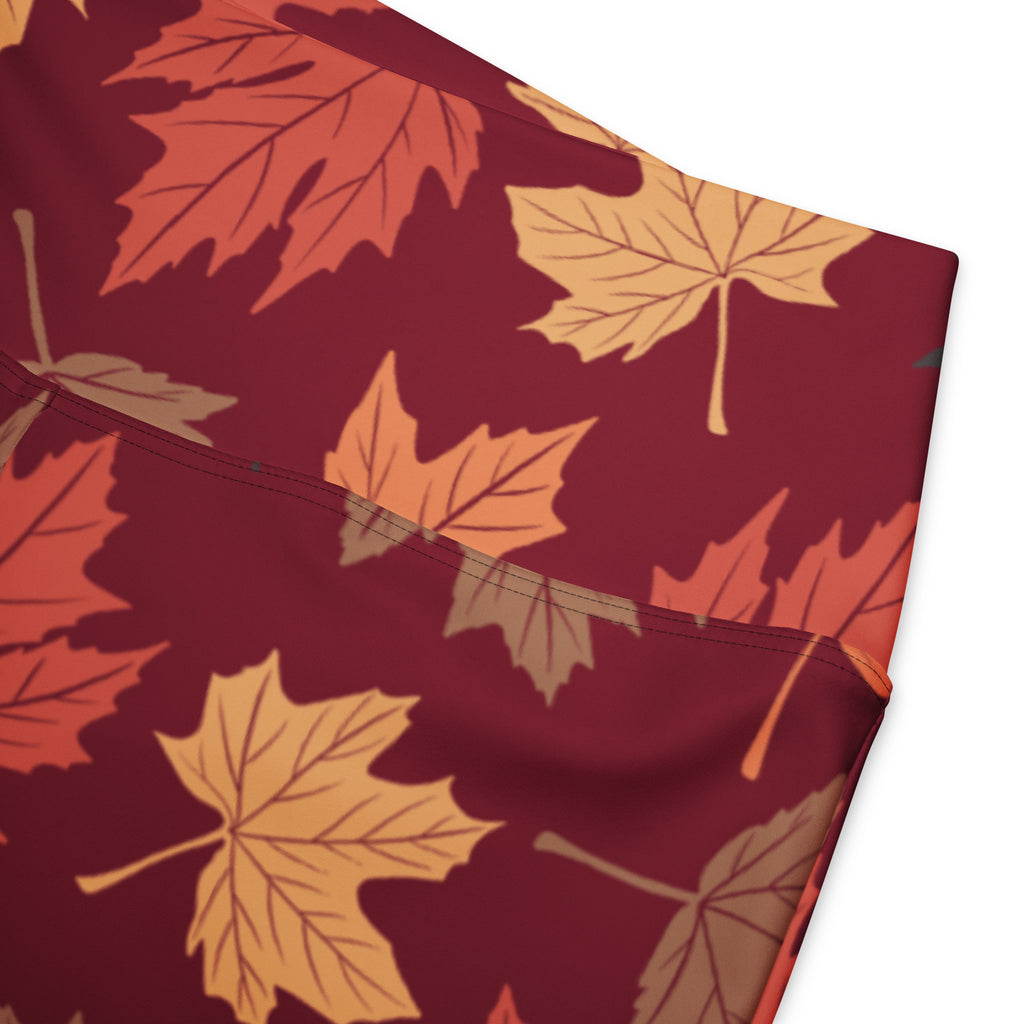 Women’s maroon high waist flare leggings with a stylized autumn maple leaf pattern in orange yellow and brown