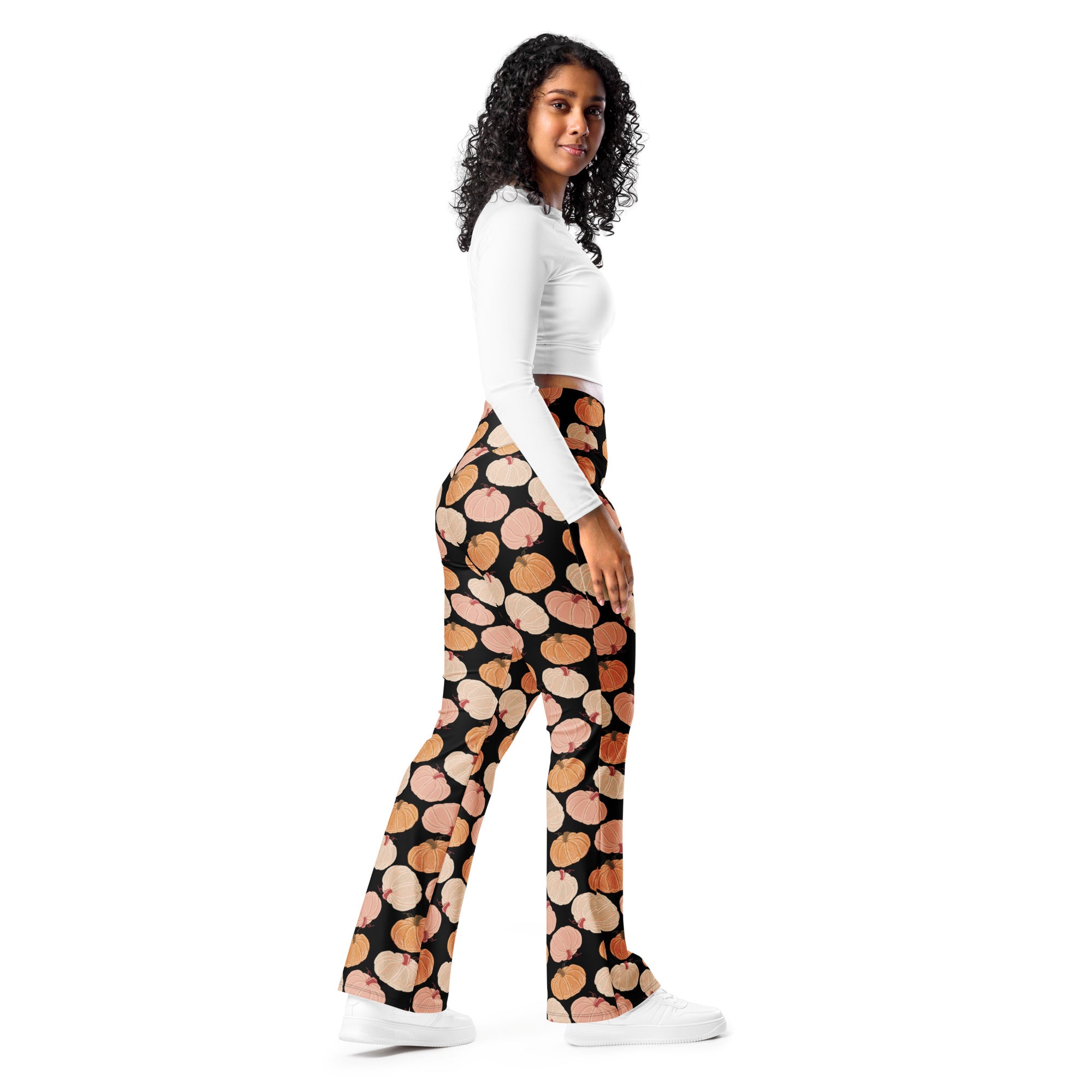 Women’s black high-waisted flare legging pants with a playful orange and pink pumpkin pattern