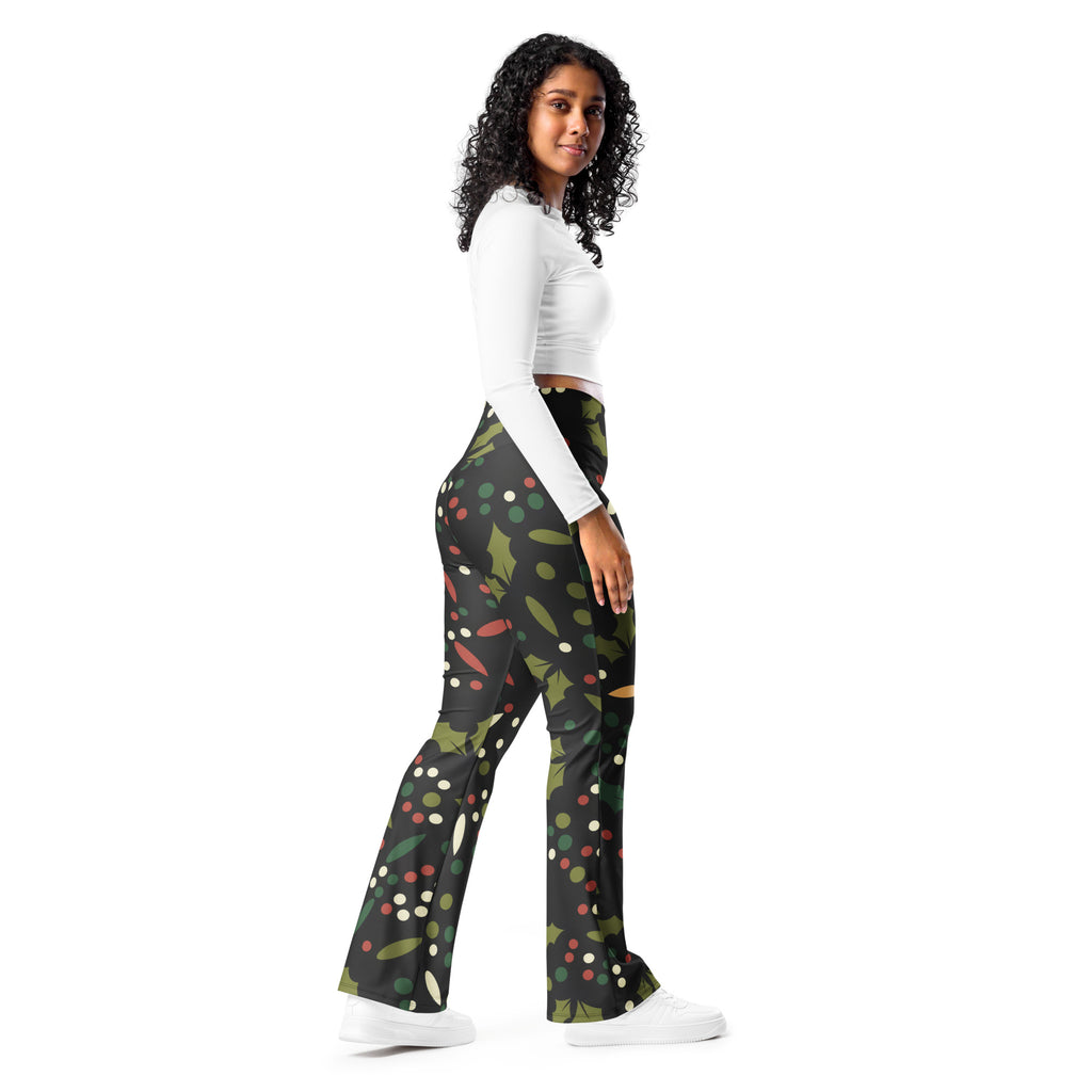 Women’s black flared pants with festive green holly leaves red berries and white dots holiday pattern