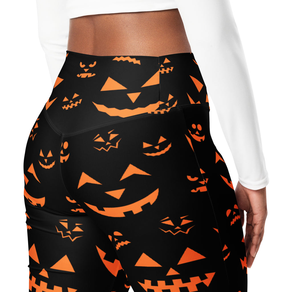 Black high-waisted flare leggings with vibrant orange jack-o-lantern face pattern for women’s Halloween wear