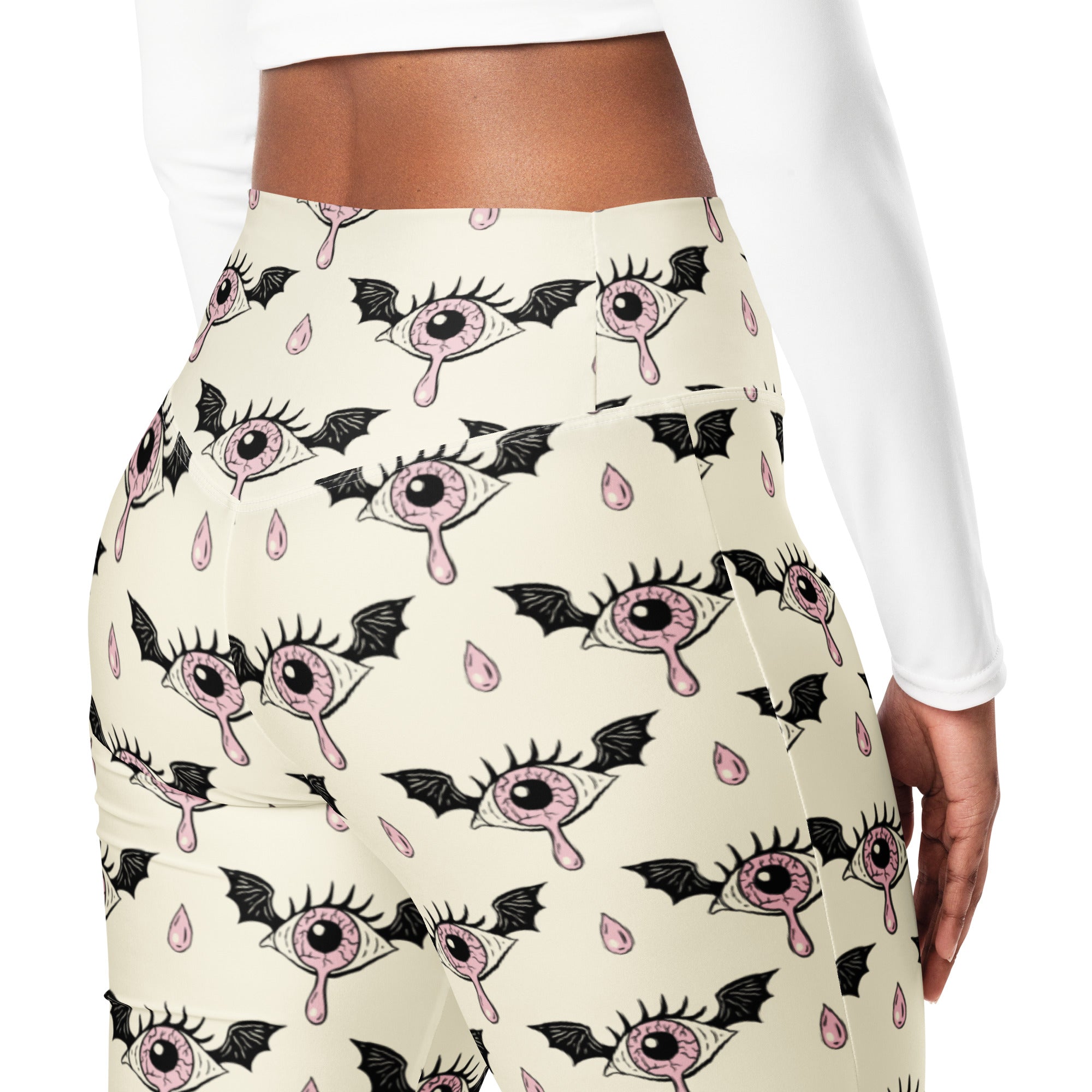 Cream-colored high-waisted women’s gothic eyeball bat leggings with pink eyelid eyes and black bat wing patterns