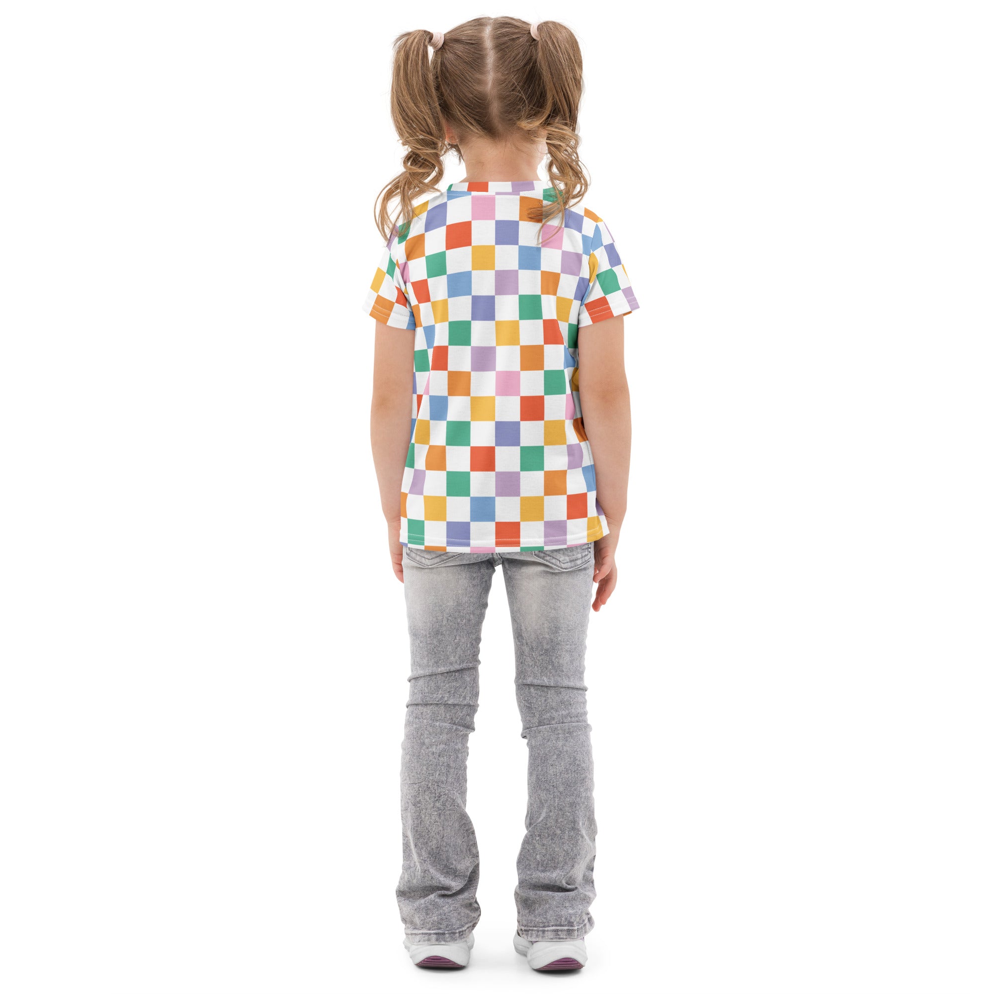 A child wearing a kids rainbow checkerboard cotton t-shirt with colorful checkered rainbow squares and faded gray jeans