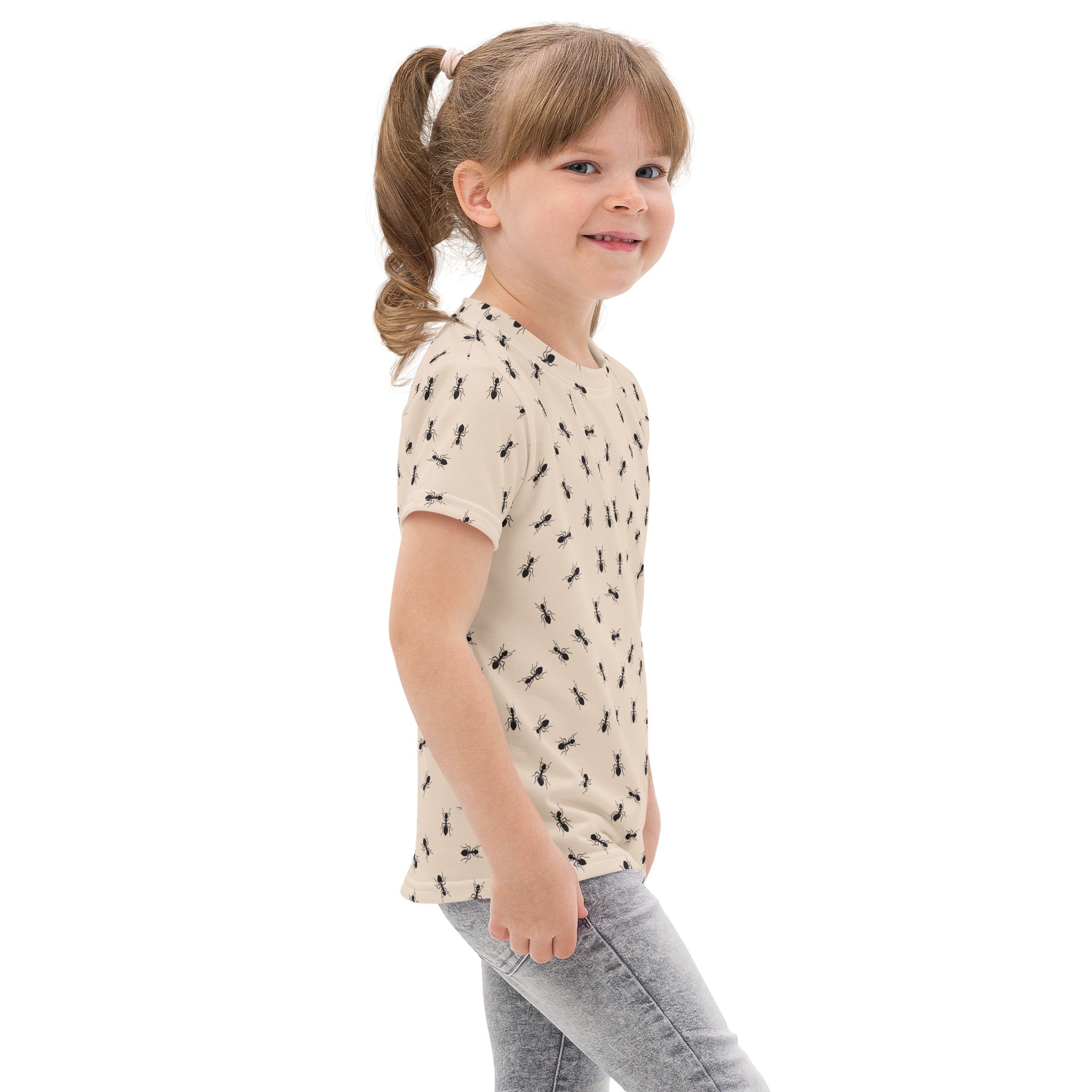 A child wearing a beige cotton kids ant t-shirt with a black ant pattern on the front