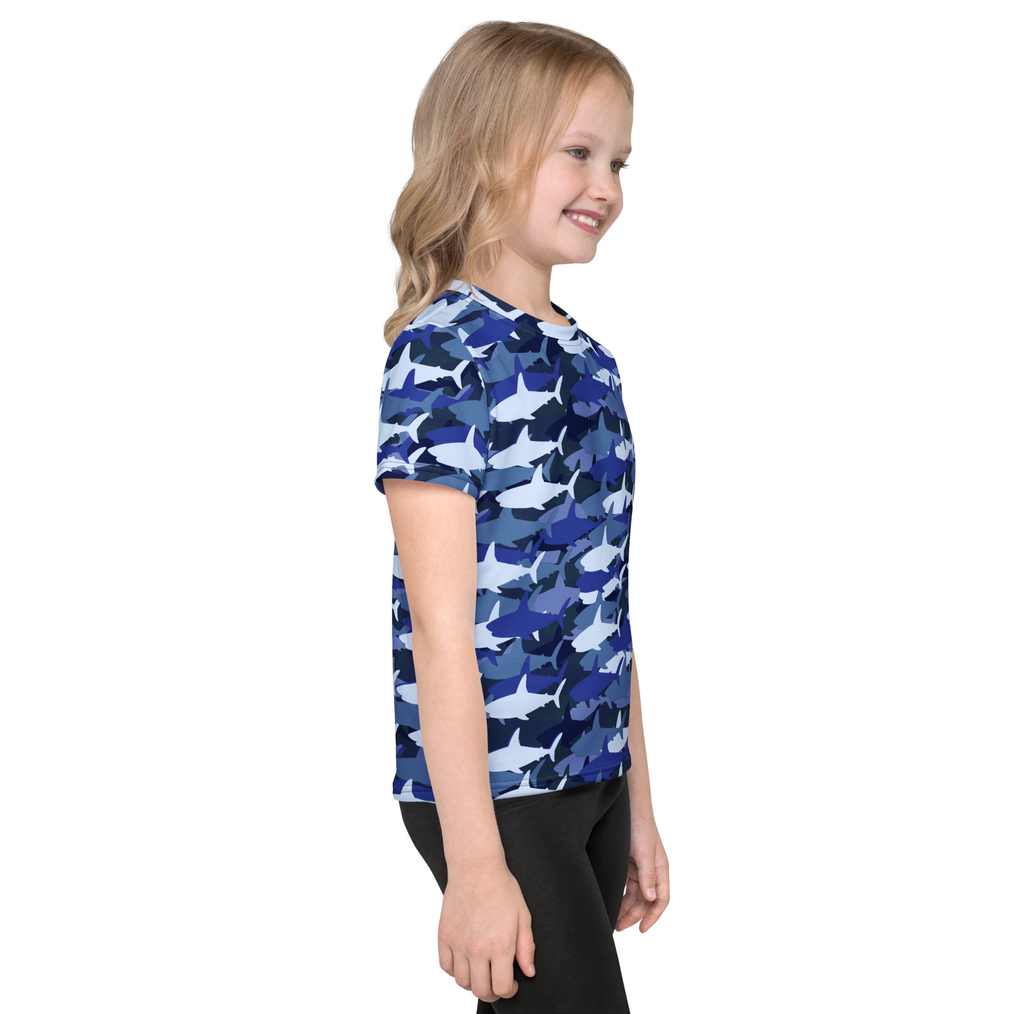 A child wearing a kids blue shark t-shirt with a short-sleeved blue shark camouflage pattern