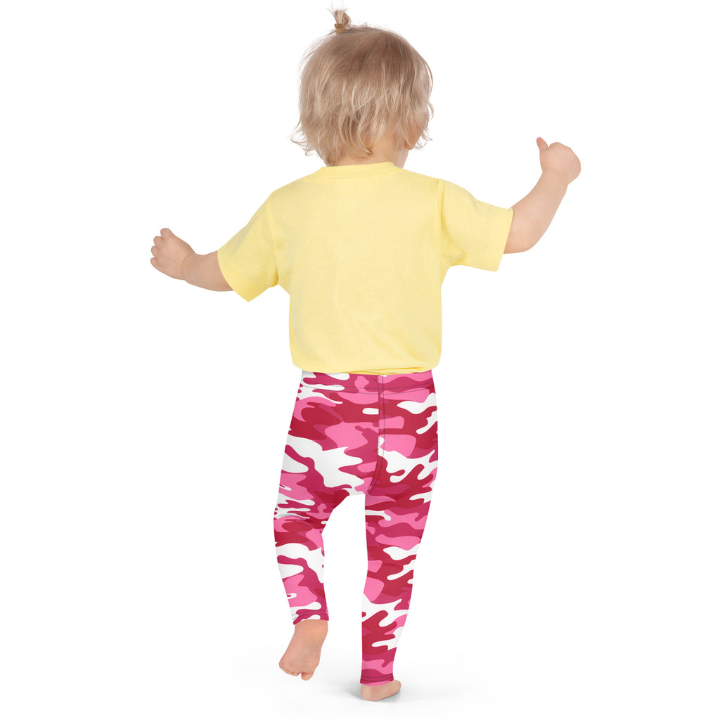 A toddler wearing girls pink camouflage buttery soft leggings and a yellow short-sleeved shirt standing upright