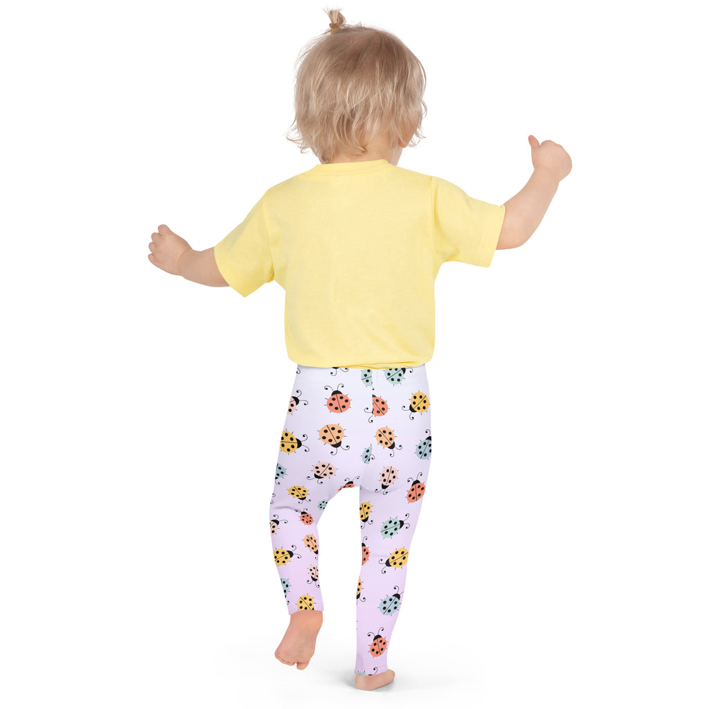 A child wearing girls colorful ladybug buttery soft light purple leggings with a yellow short-sleeved shirt