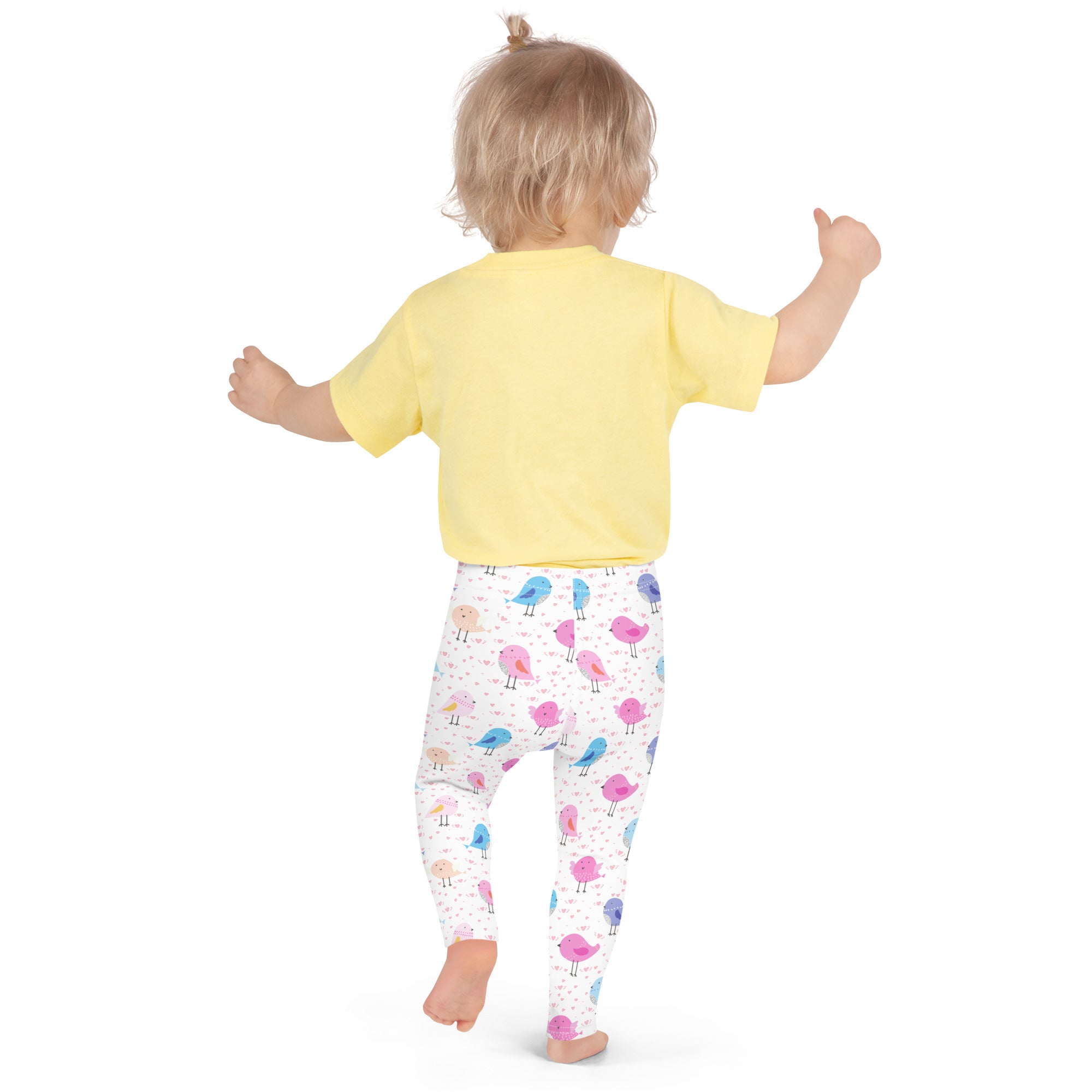 A child wearing girls colorful birds buttery soft white leggings with pink blue and purple cartoon birds and a yellow shirt