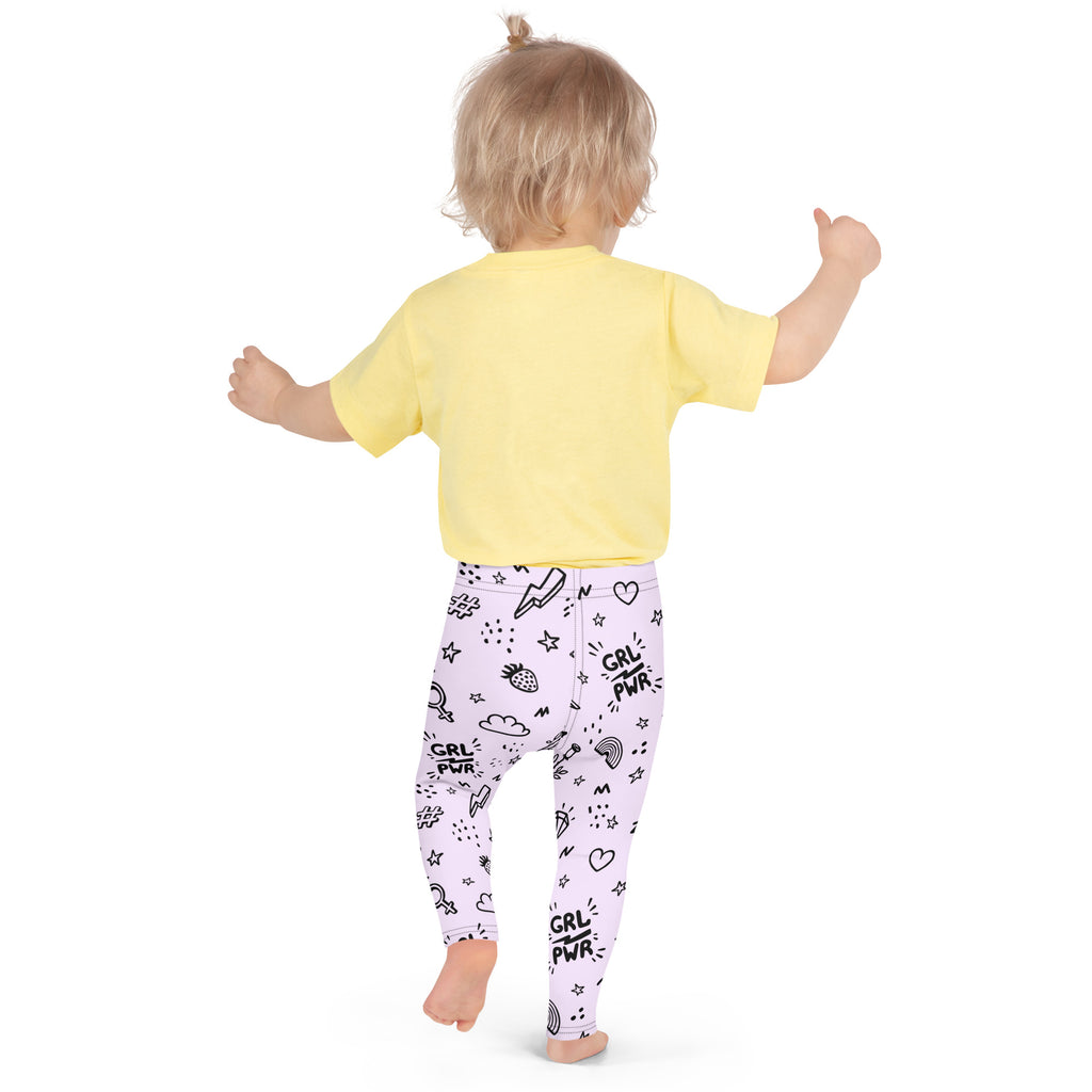 A child wearing light purple girl power kids buttery soft leggings with black playful doodles and a yellow short-sleeved shirt